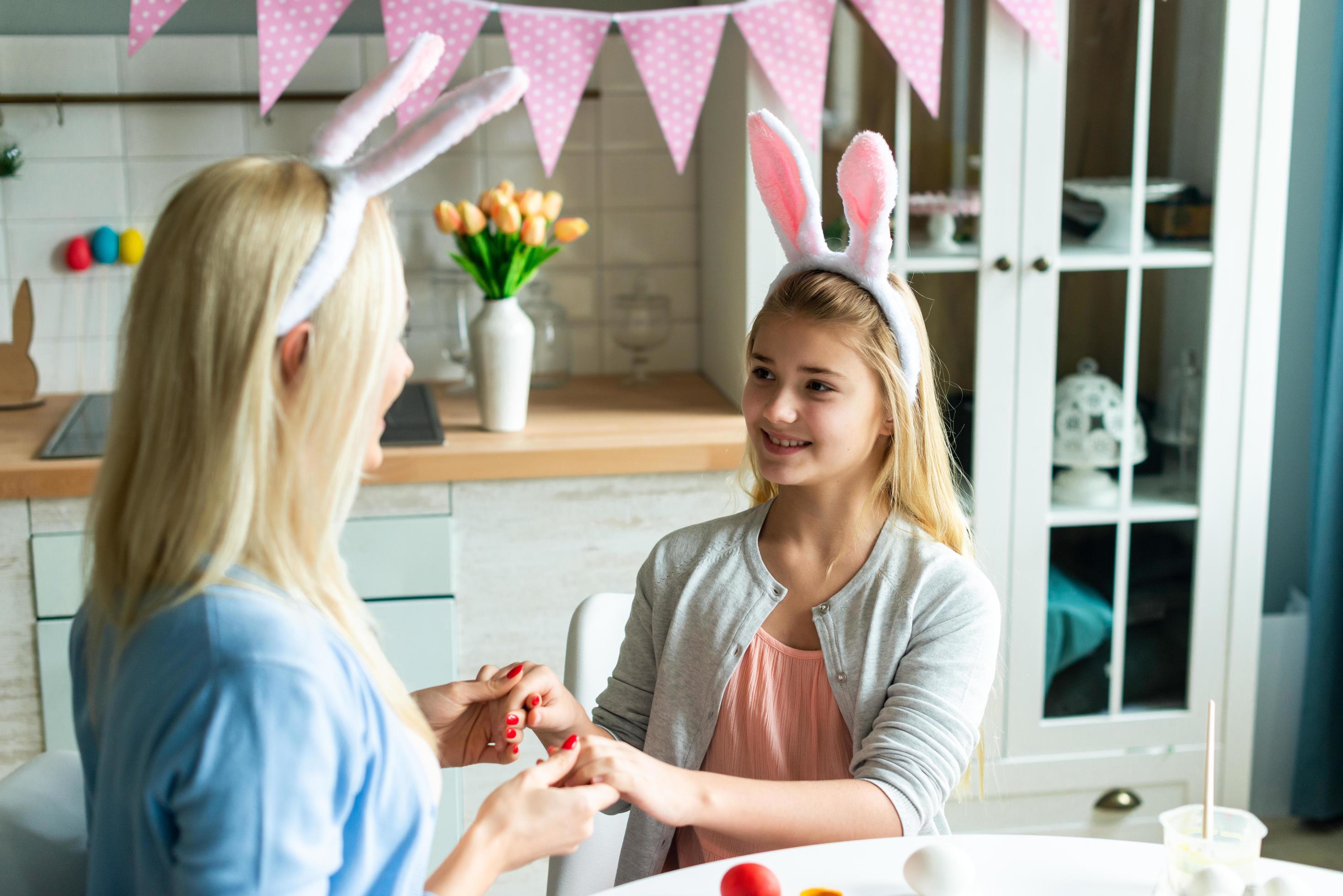 Happy family preparing for Easter. Cute little child girl wearing bunny ears on Easter day. Stock Free