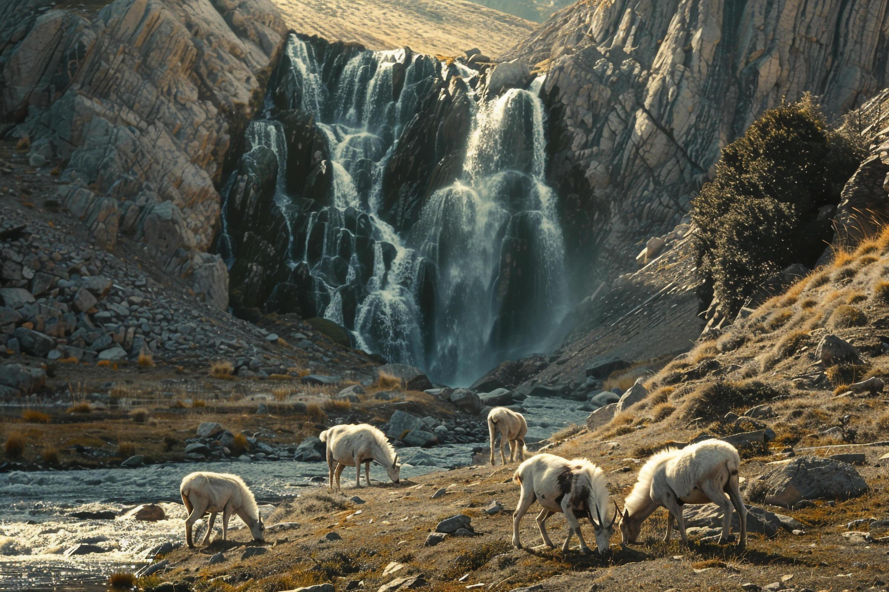 Serene waterfall in a mountainous landscape with a family of mountain goats nature background Stock Free