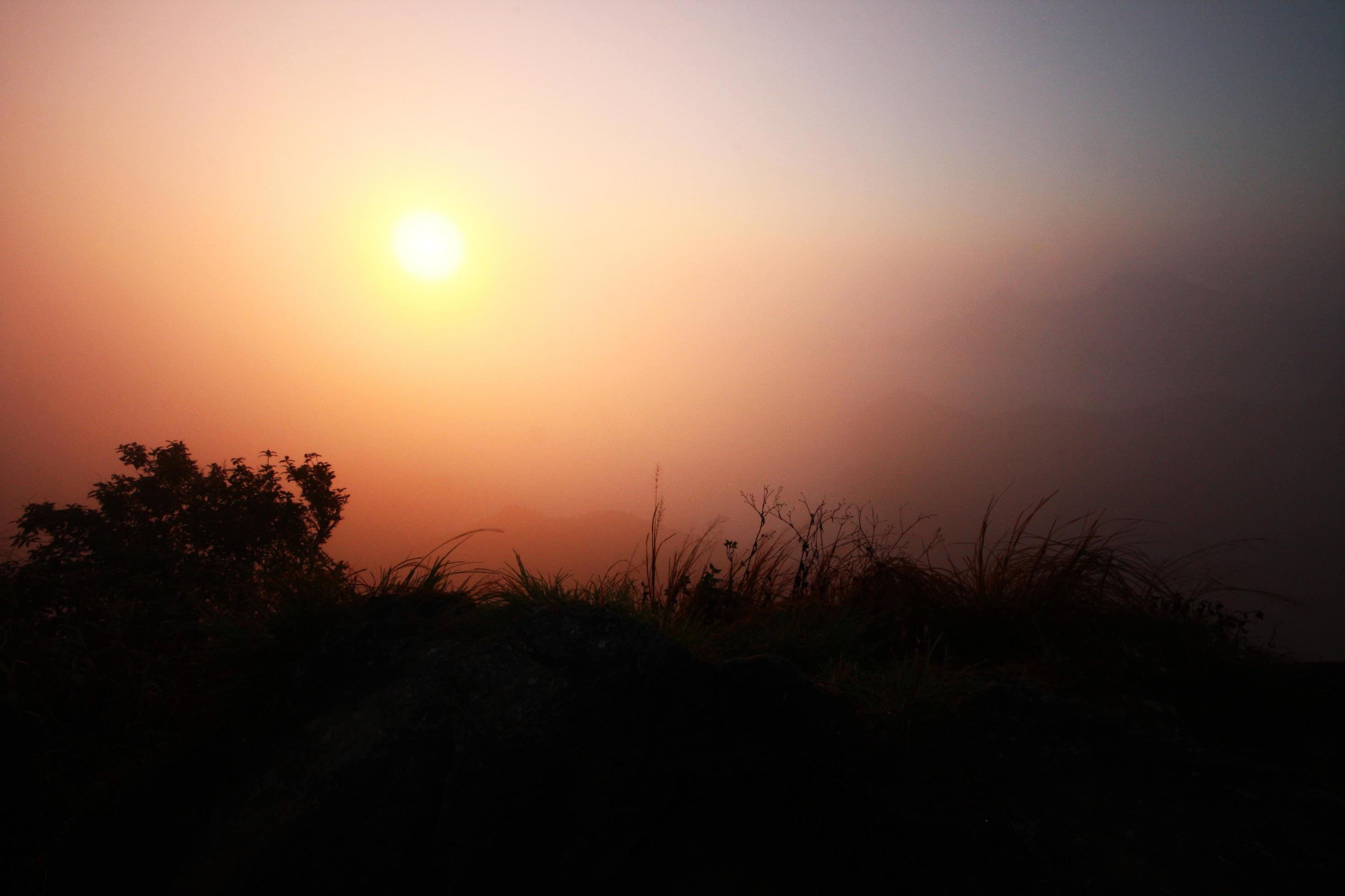 Beautiful silhouette landscape valley of mountain with fog and mist in winter of sunrise shining on the sky Stock Free