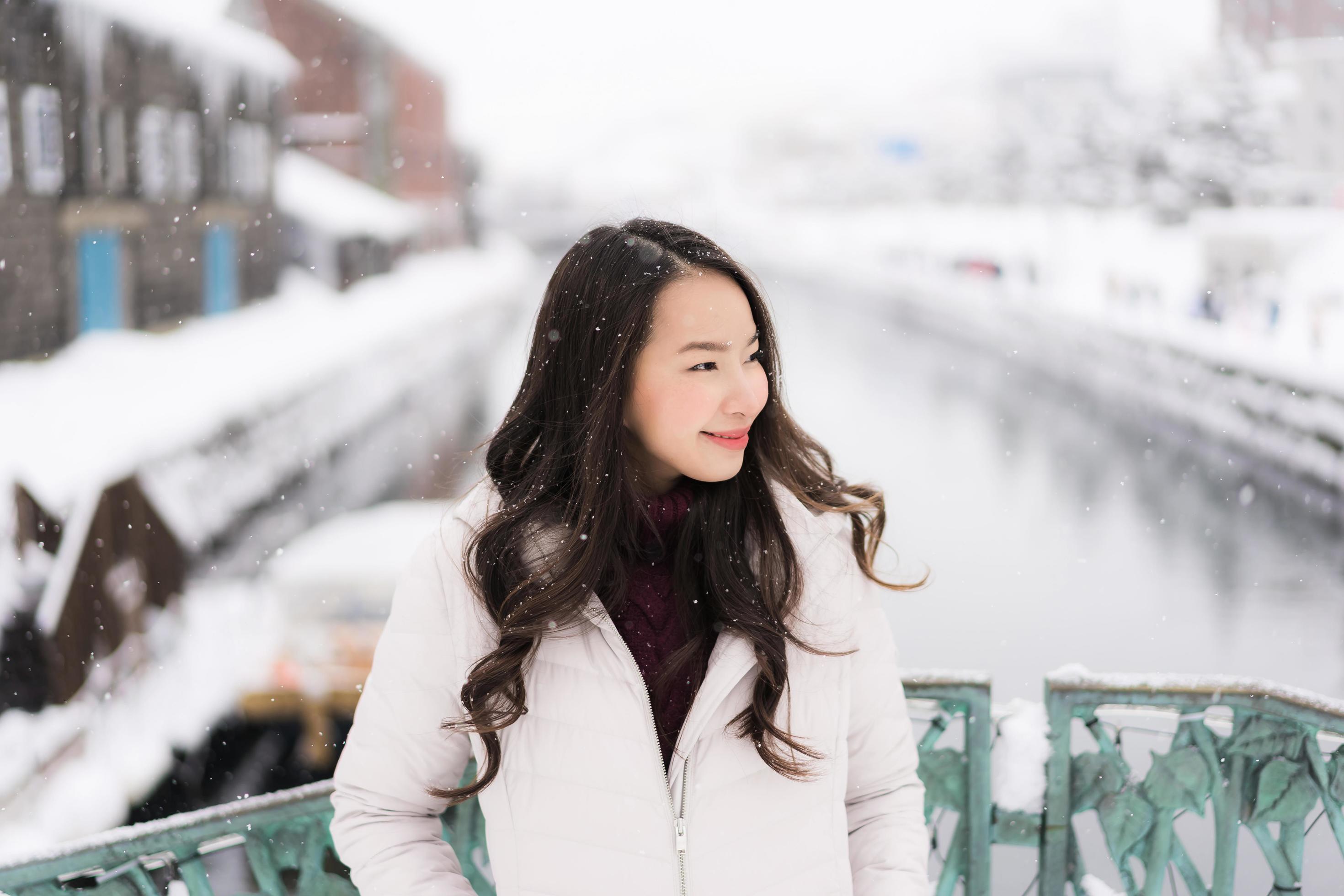 asian woman smiling happy for travel in snow winter season Stock Free