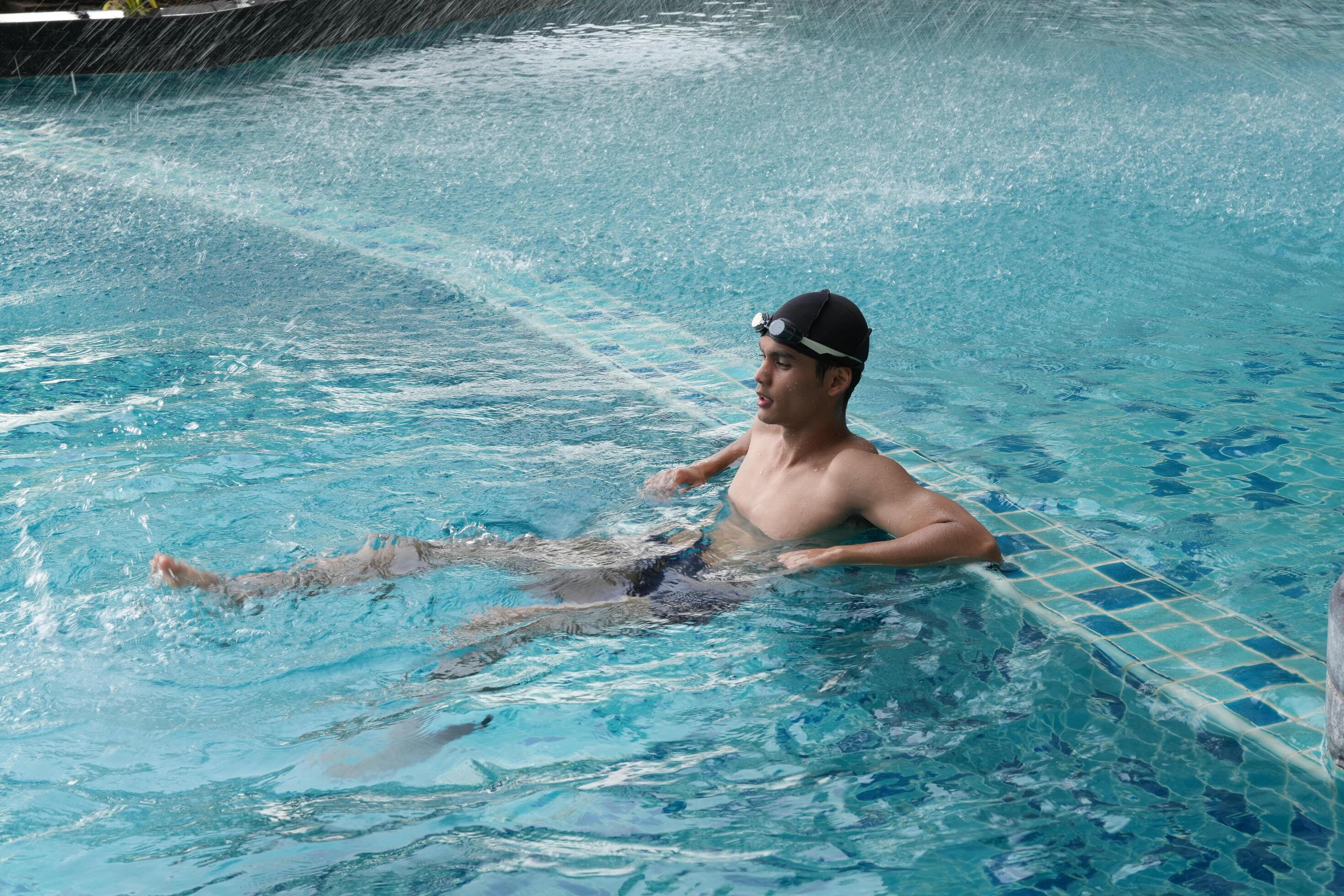 Asian men practicing swimming and preparing to play water polo and stretching and resting for water sports. Stock Free