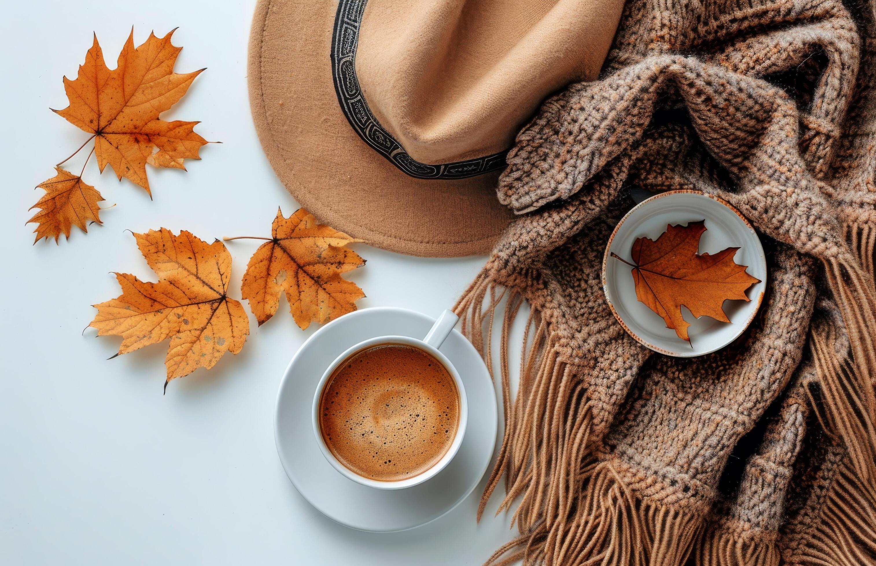 Autumnal Coffee Cup on White Table With Brown Scarf and Fall Leaves Stock Free