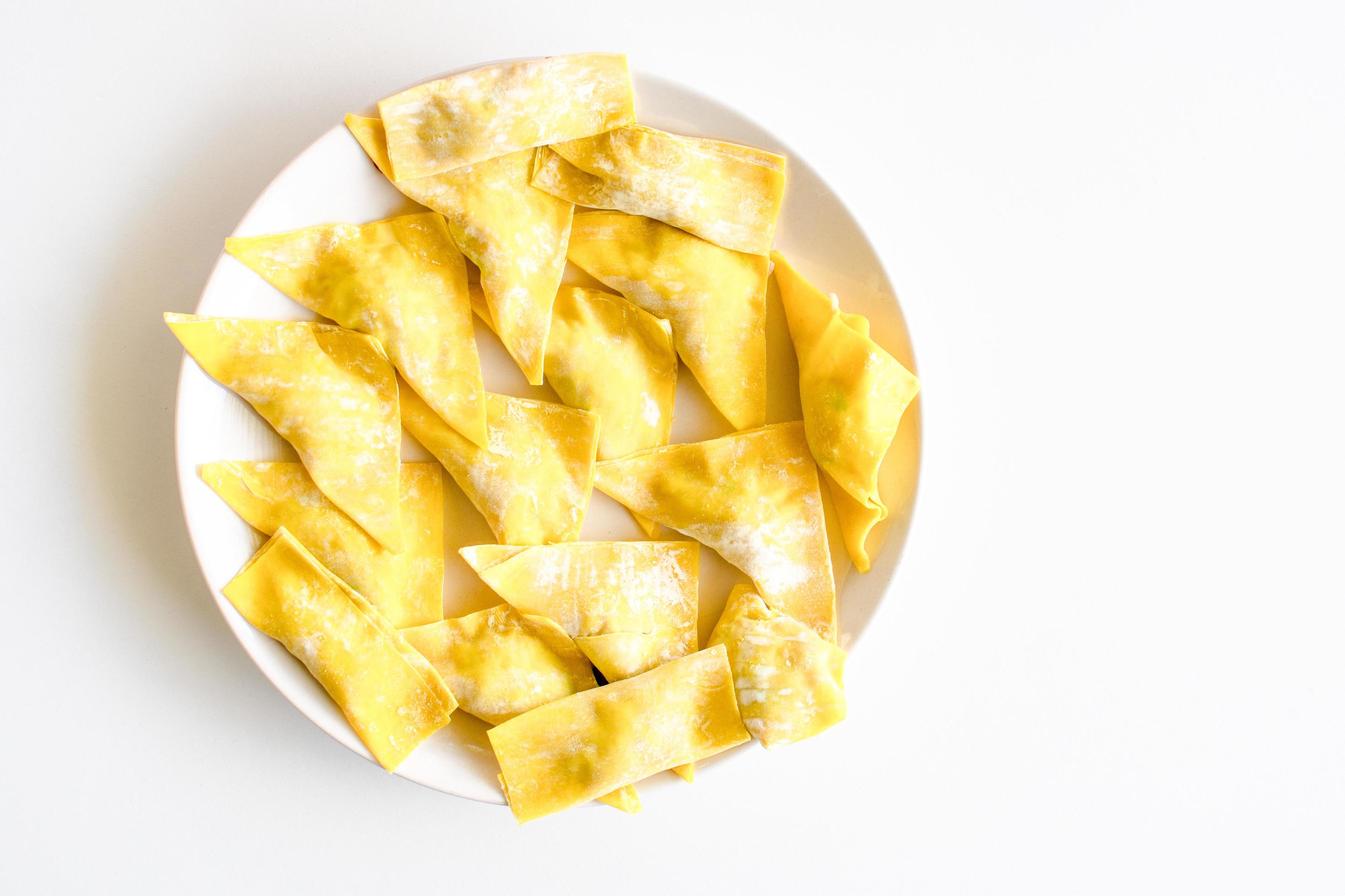 The yellow food is sliced on a white plate and placed on a white-ground table. Closeup, copy space on right for design or text, white background Stock Free