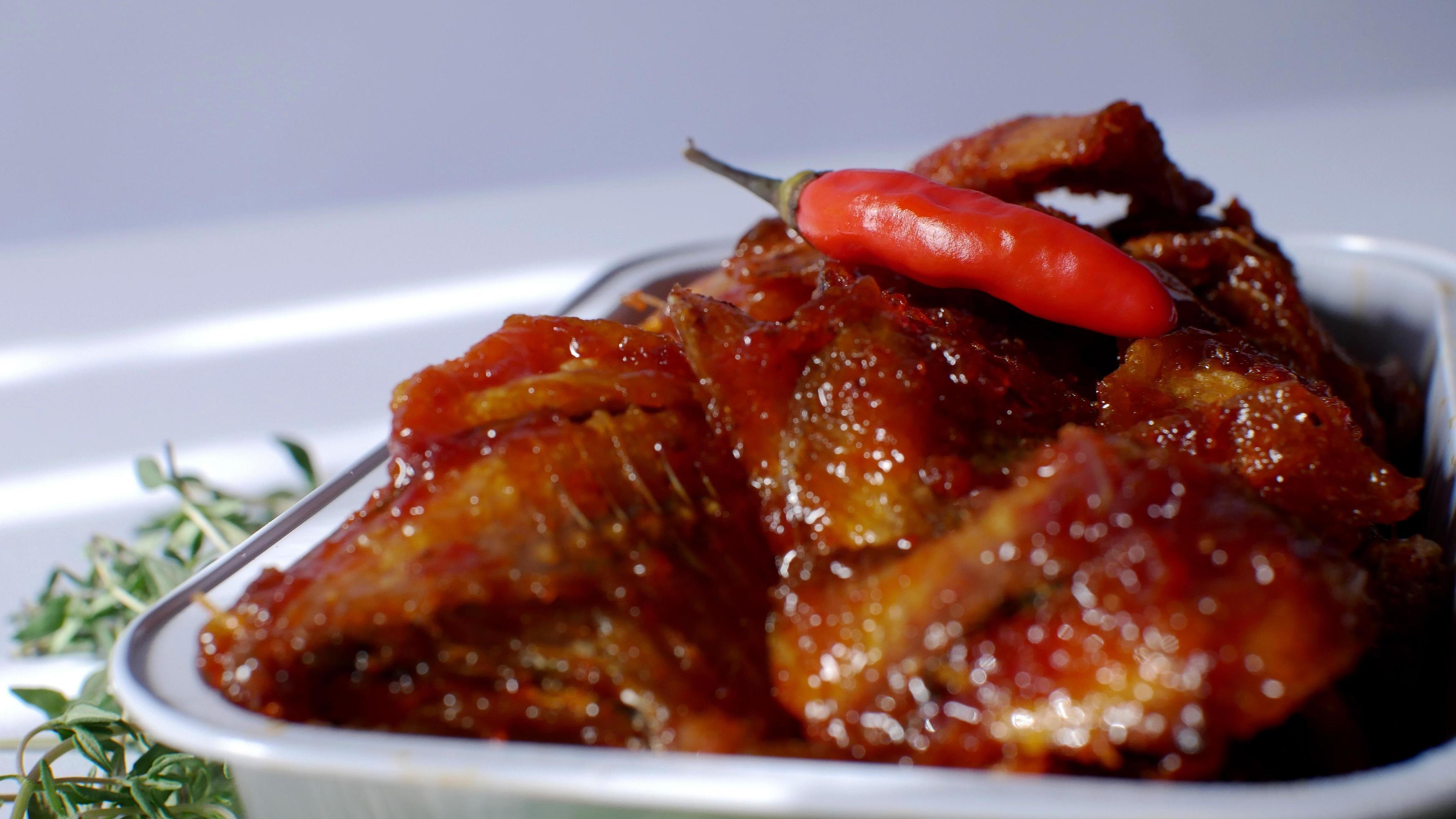 salted fish with spicy sweet and sour seasoning Indonesian food served simply in an aluminum place with white background Stock Free