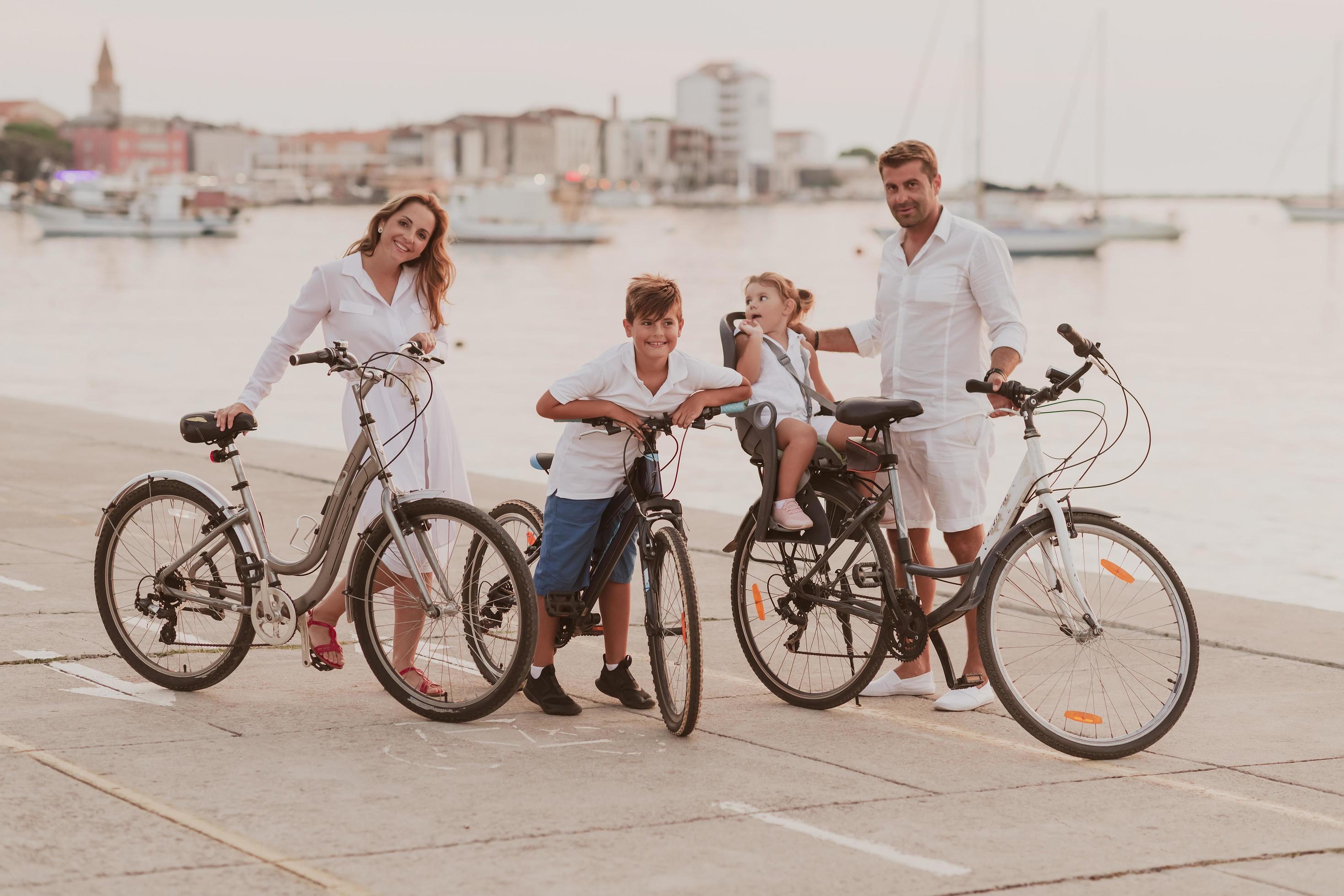 The happy family enjoys a beautiful morning by the sea riding a bike together and spending time together. The concept of a happy family Stock Free