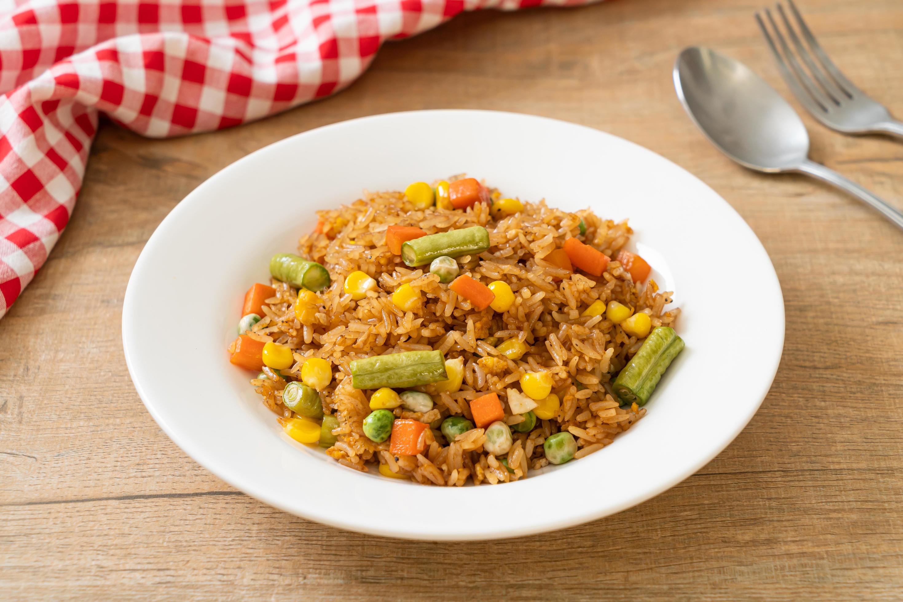 Fried rice with green peas, carrots, and corn – vegetarian and healthy food style Stock Free