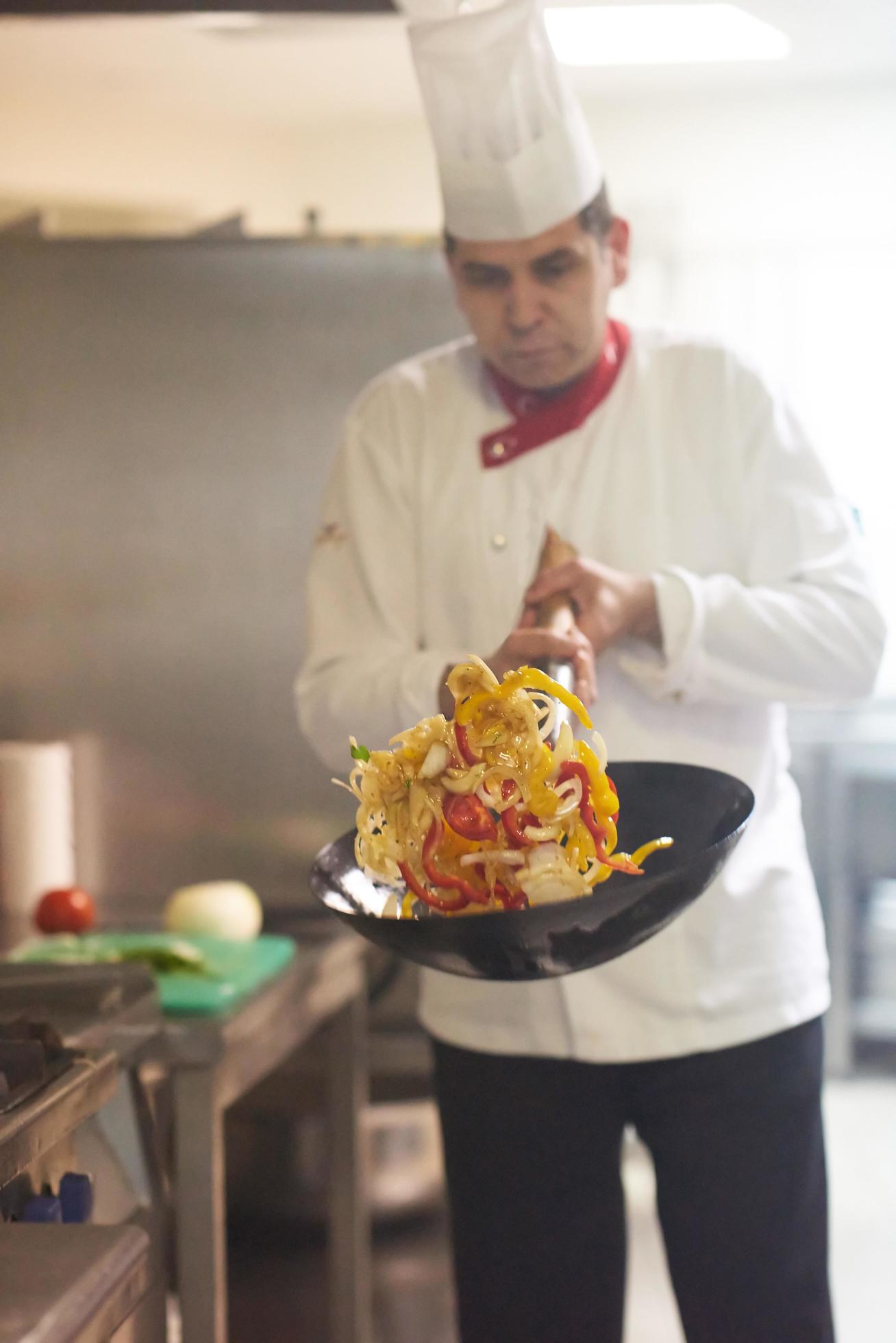 chef in hotel kitchen prepare food with fire Stock Free