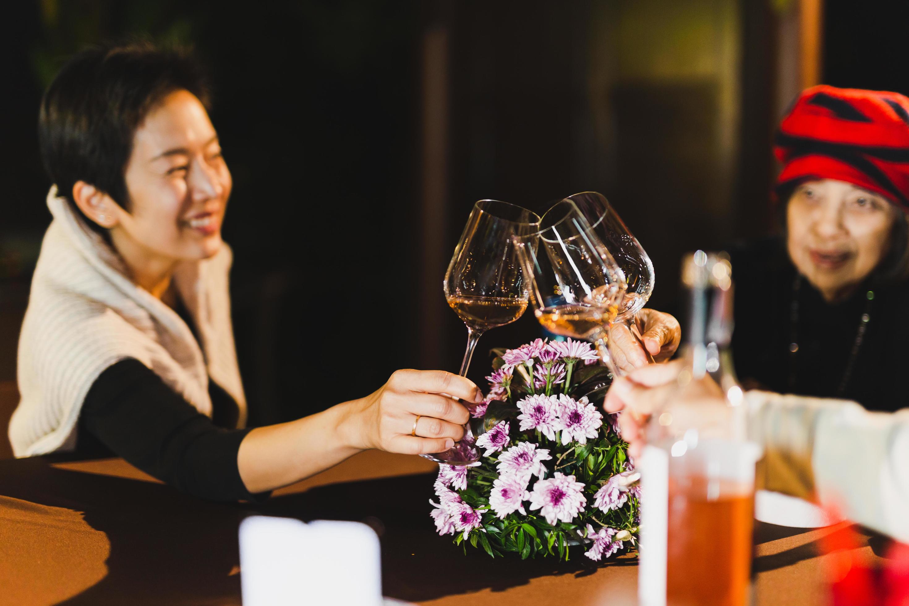 Happy family holding wine glasses toasting at dinner table. Stock Free