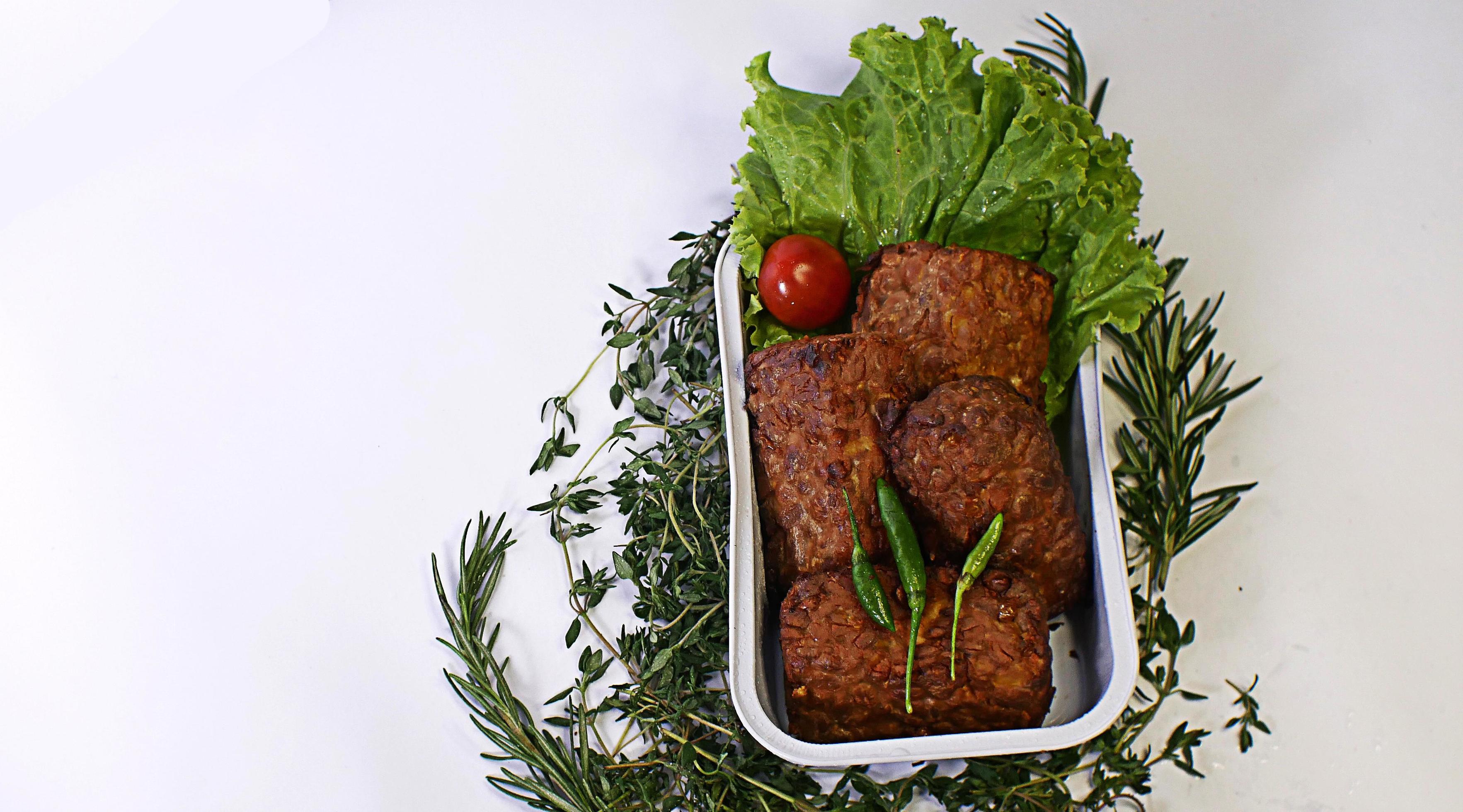 Fried soybean mushrooms, small tomatoes, chilies and salad in one aluminum container. typical indonesian street food on a white background Stock Free