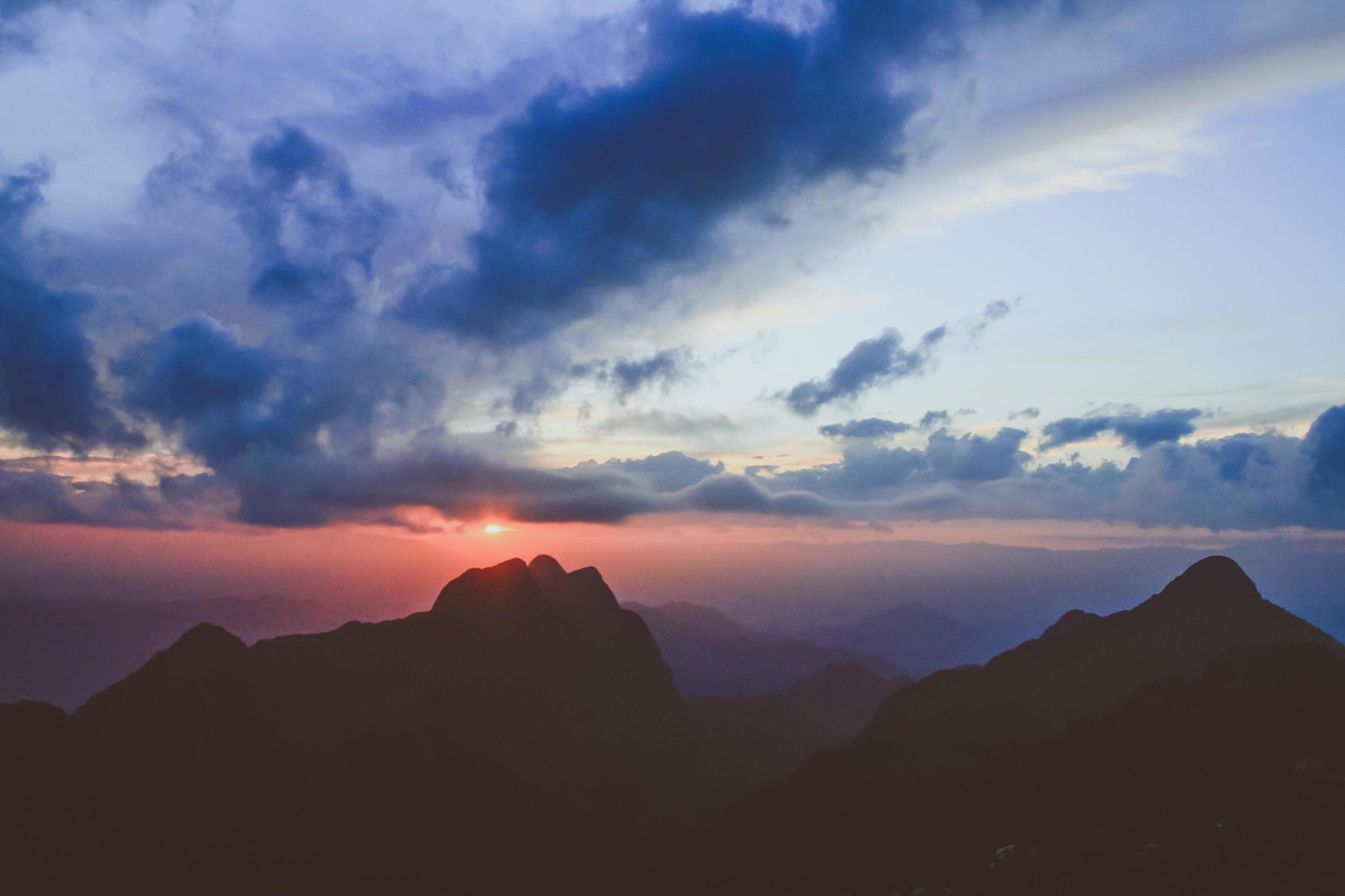 Sunset in sky and cloud, beautiful colorful twilight time with silhouette of mountain. Stock Free