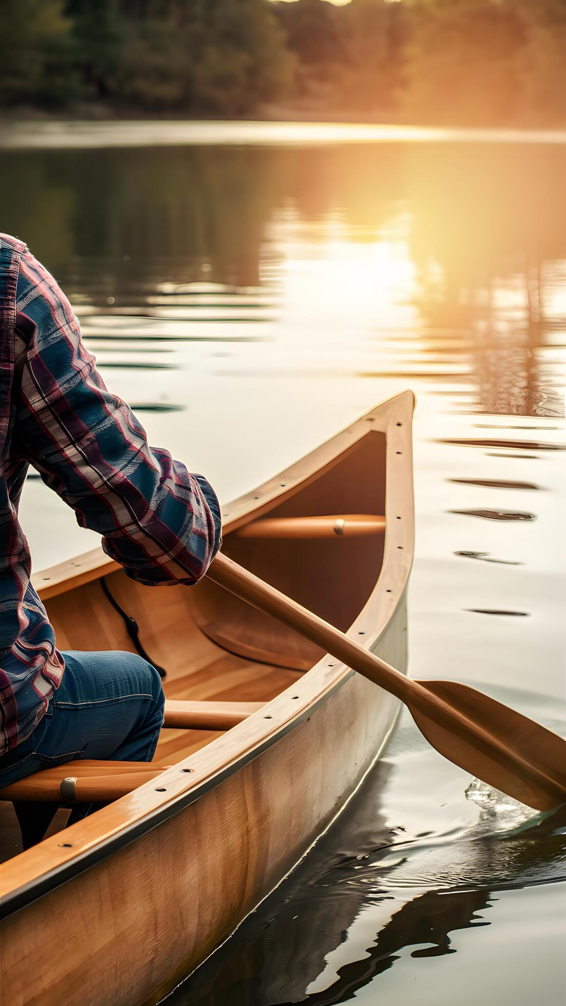 Plaid shirted person paddles wooden canoe on calm lake under golden sunset Vertical Mobile Wallpaper Stock Free