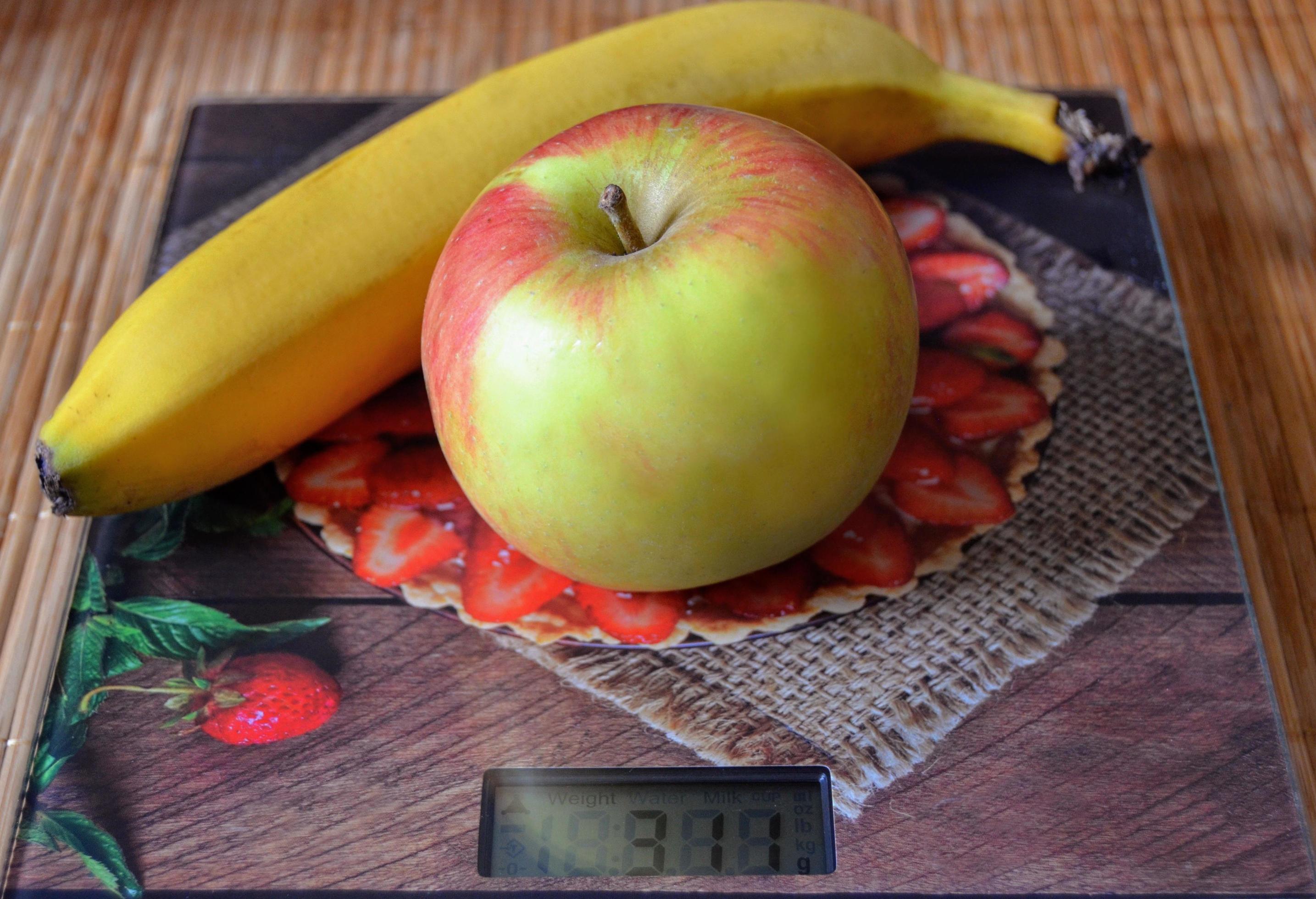 Apple and banana on the scale. Topic cooking at home, healthy food, diet. Stock Free