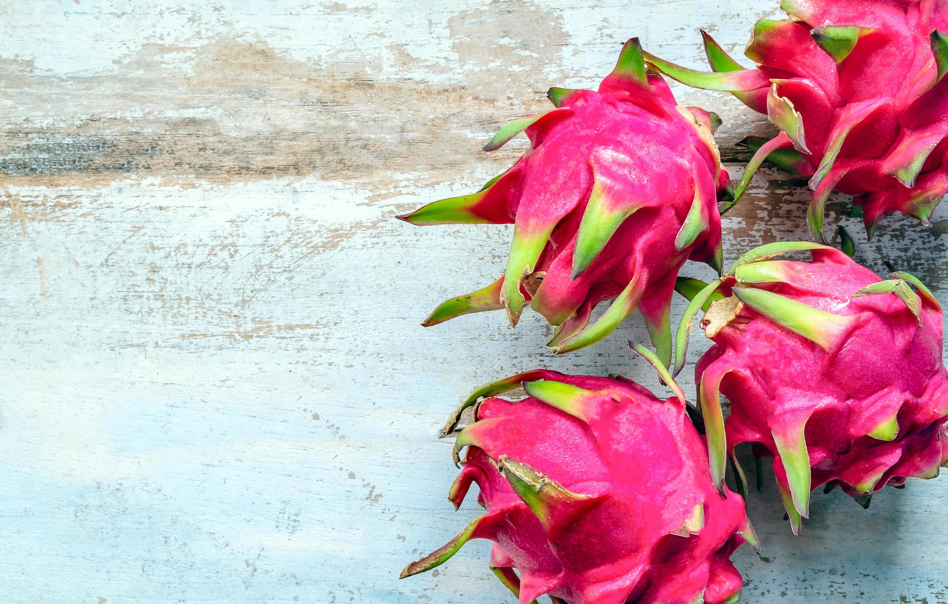 Red dragon fruit of the genus Hylocereus belongs to the family Cactaceae, which is the same family as cactus on wooden background Stock Free