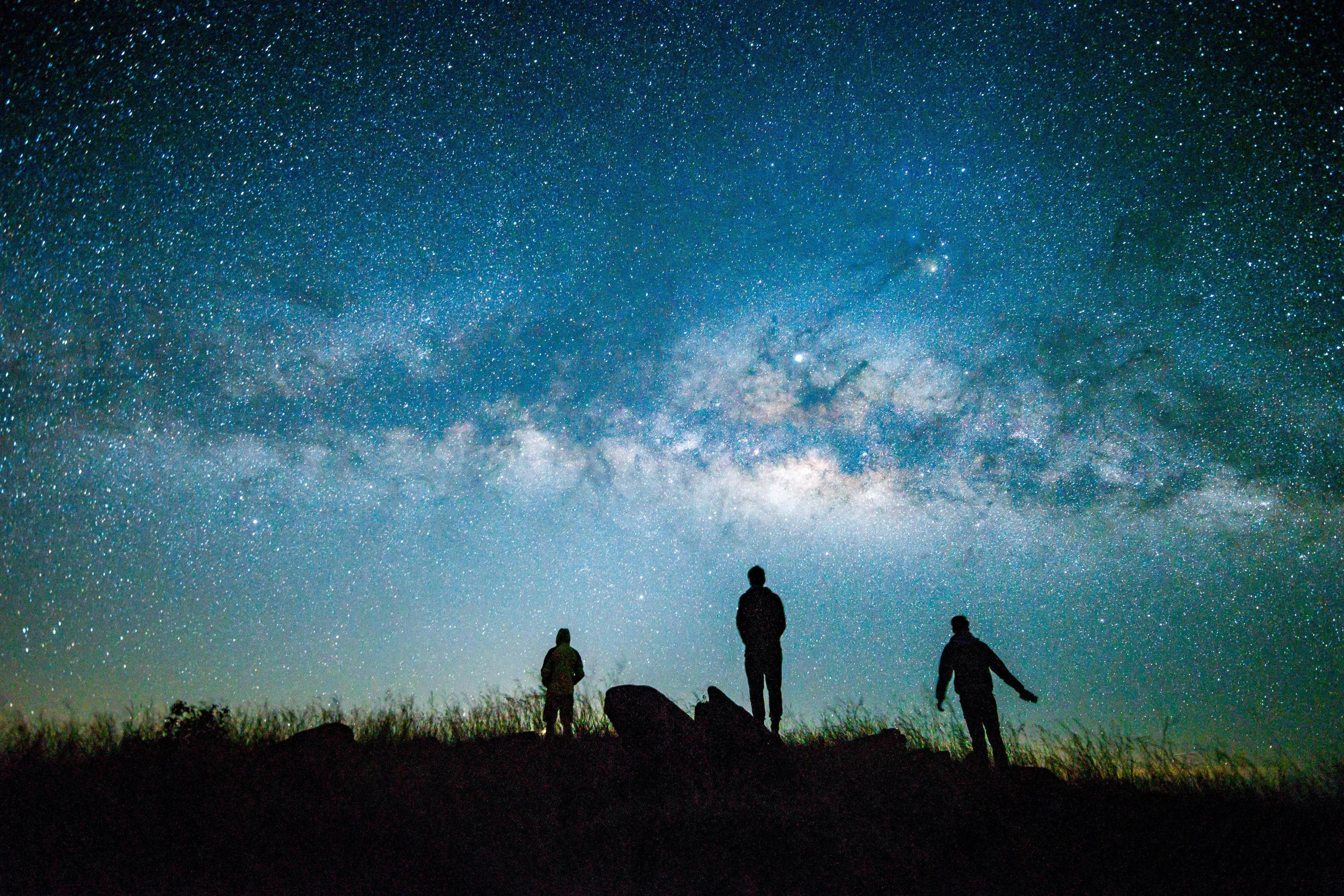 Blue dark night sky with with star Milky way Space background and silhouette of a standing happy man Stock Free