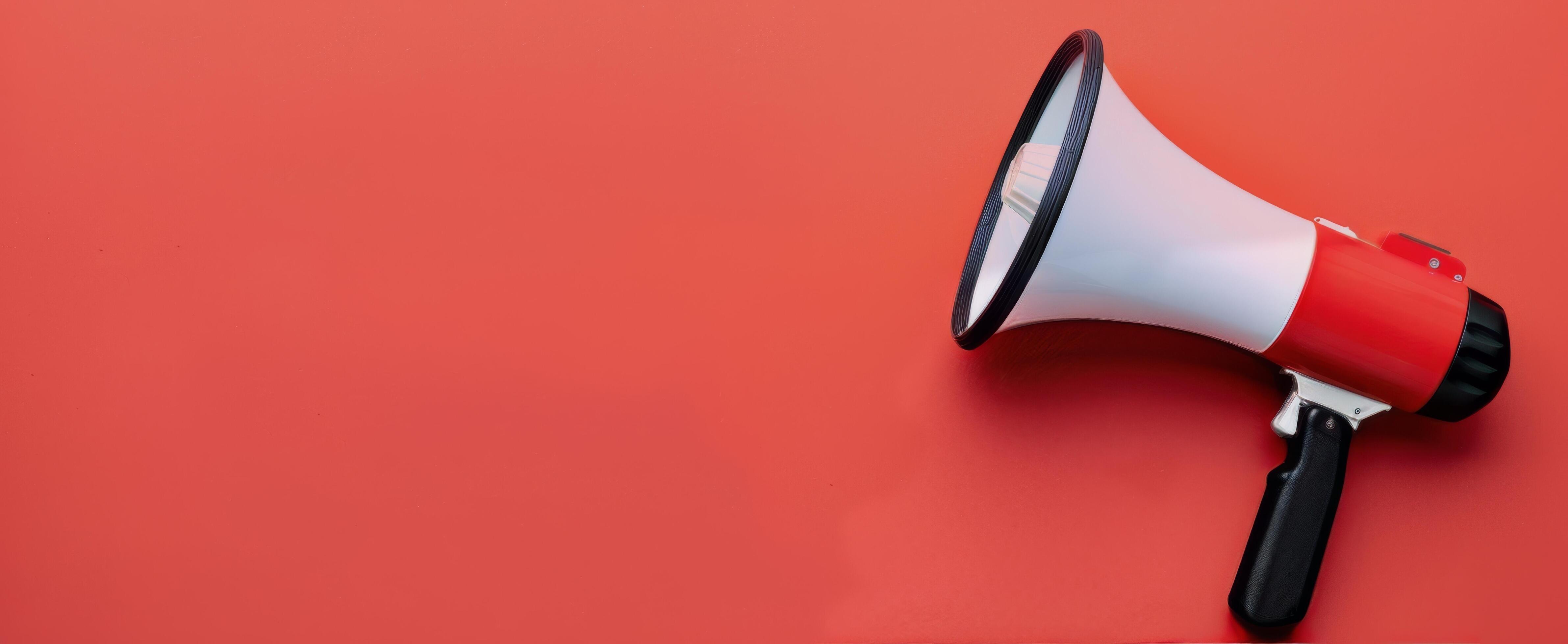 Megaphone Positioned on Red Background for Announcements and Communication Stock Free