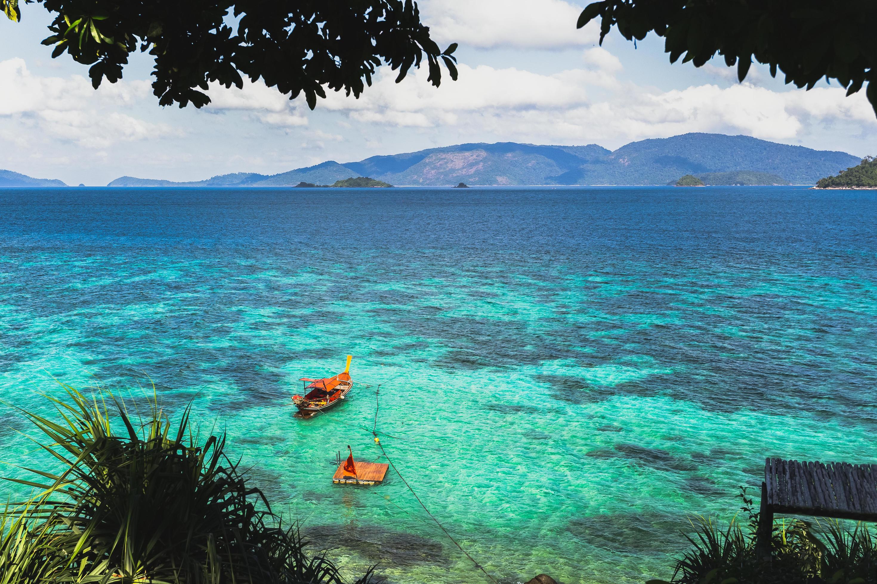 Beautiful summer landscape of tropical island with long tail boat in ocean. Stock Free