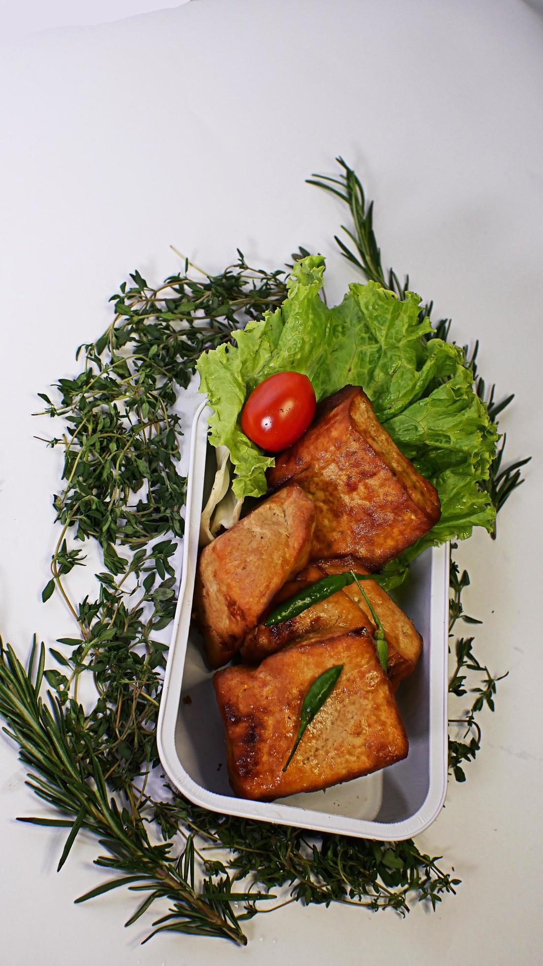 Fried tofu, small tomatoes and green chilies along with lettuce in one aluminum container, Indonesian street food on a white background Stock Free