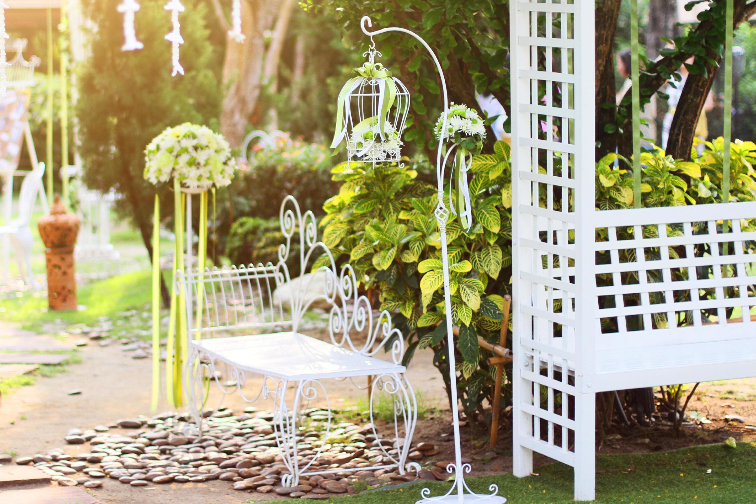 White birdcage, chair decoration with roses and white flowers hanging decoration in garden for wedding ceremony Stock Free