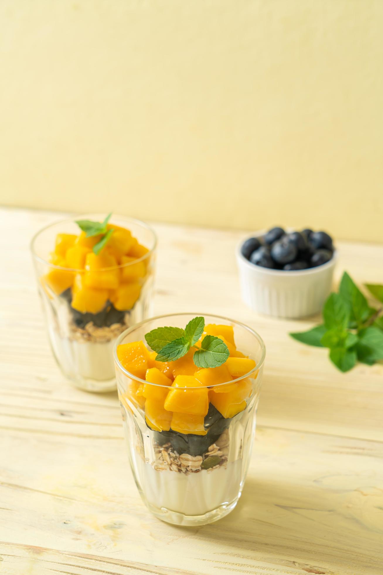 Homemade fresh mango and fresh blueberry with yogurt and granola – healthy food style Stock Free