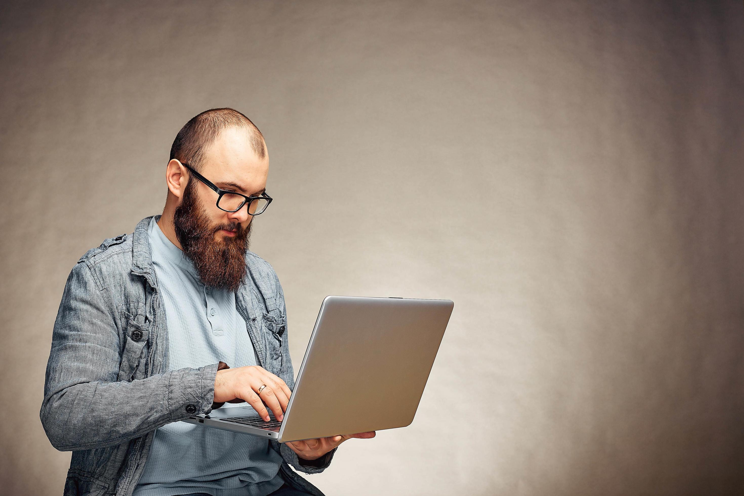 lifestyle successful freelancer man with beard achieves new goal with laptop in loft interior. Stock Free