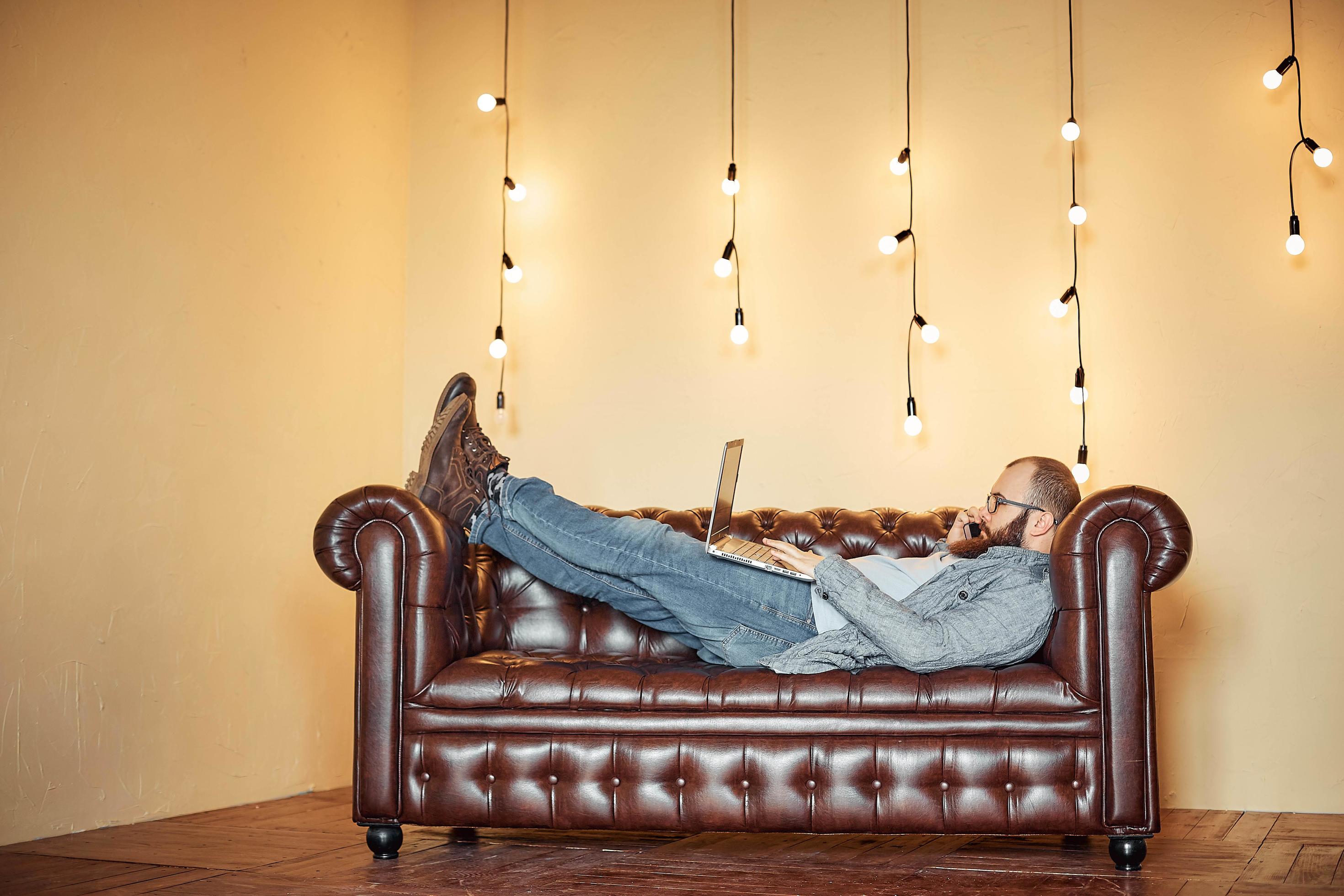 lifestyle successful freelancer man with beard achieves new goal with laptop in loft interior Stock Free