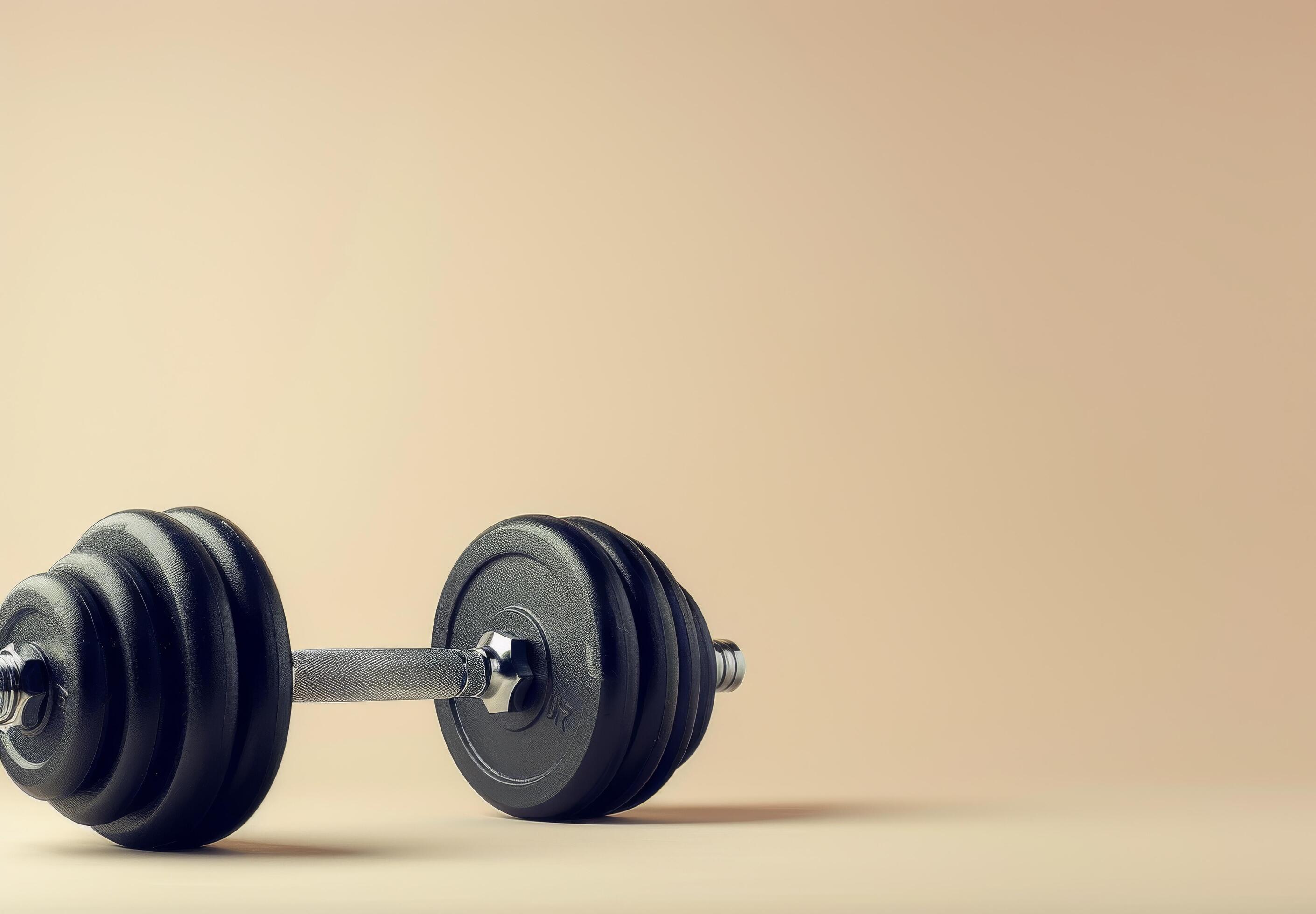 Single Black Dumbbell On A Beige Background Stock Free