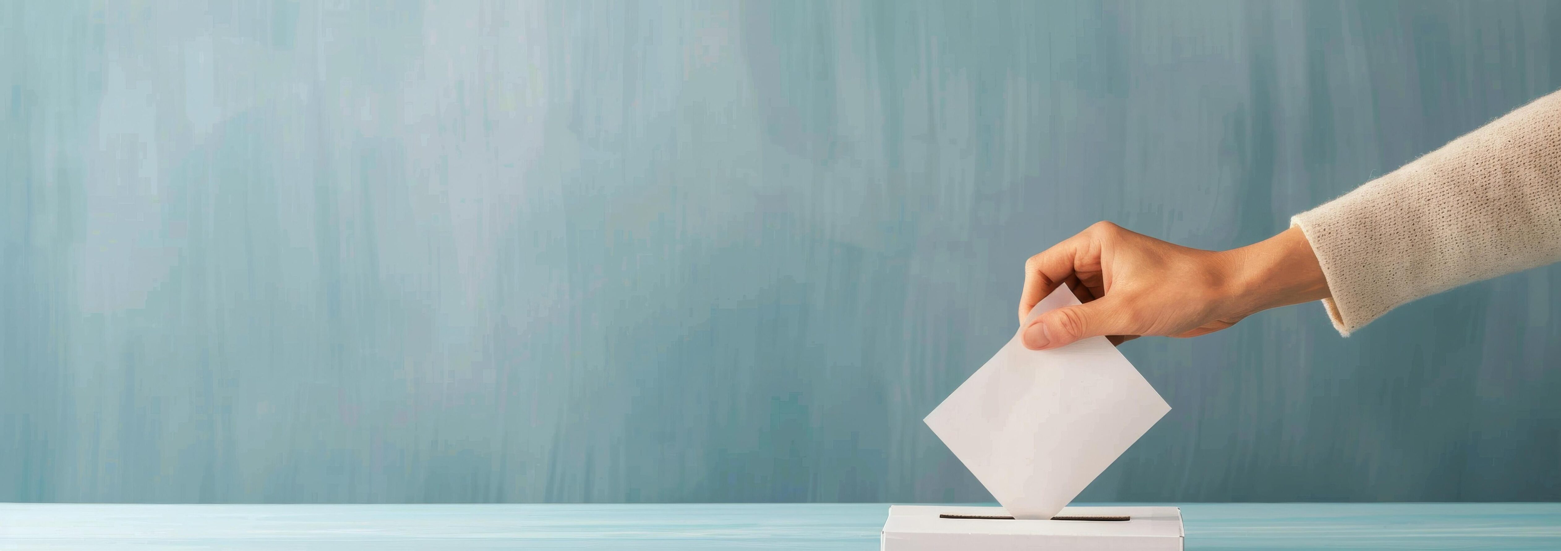 Hand Inserting Ballot Into Light Blue Box Against Teal Background Stock Free