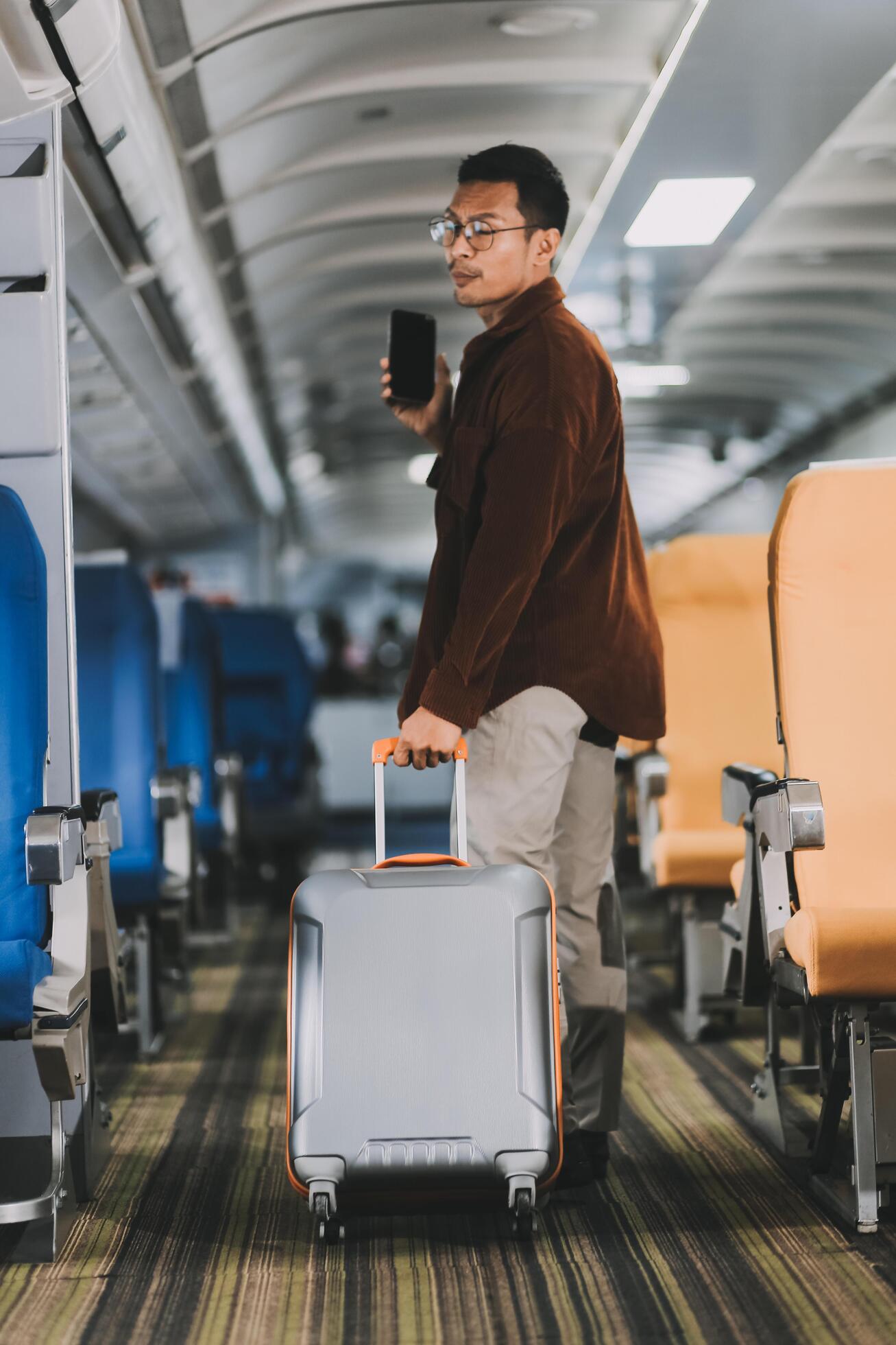 Low Section of Passenger Businessman Walking with Suitcase at the Entrance Walkway in Airport. Focus on Luggage. Low Angle View Stock Free