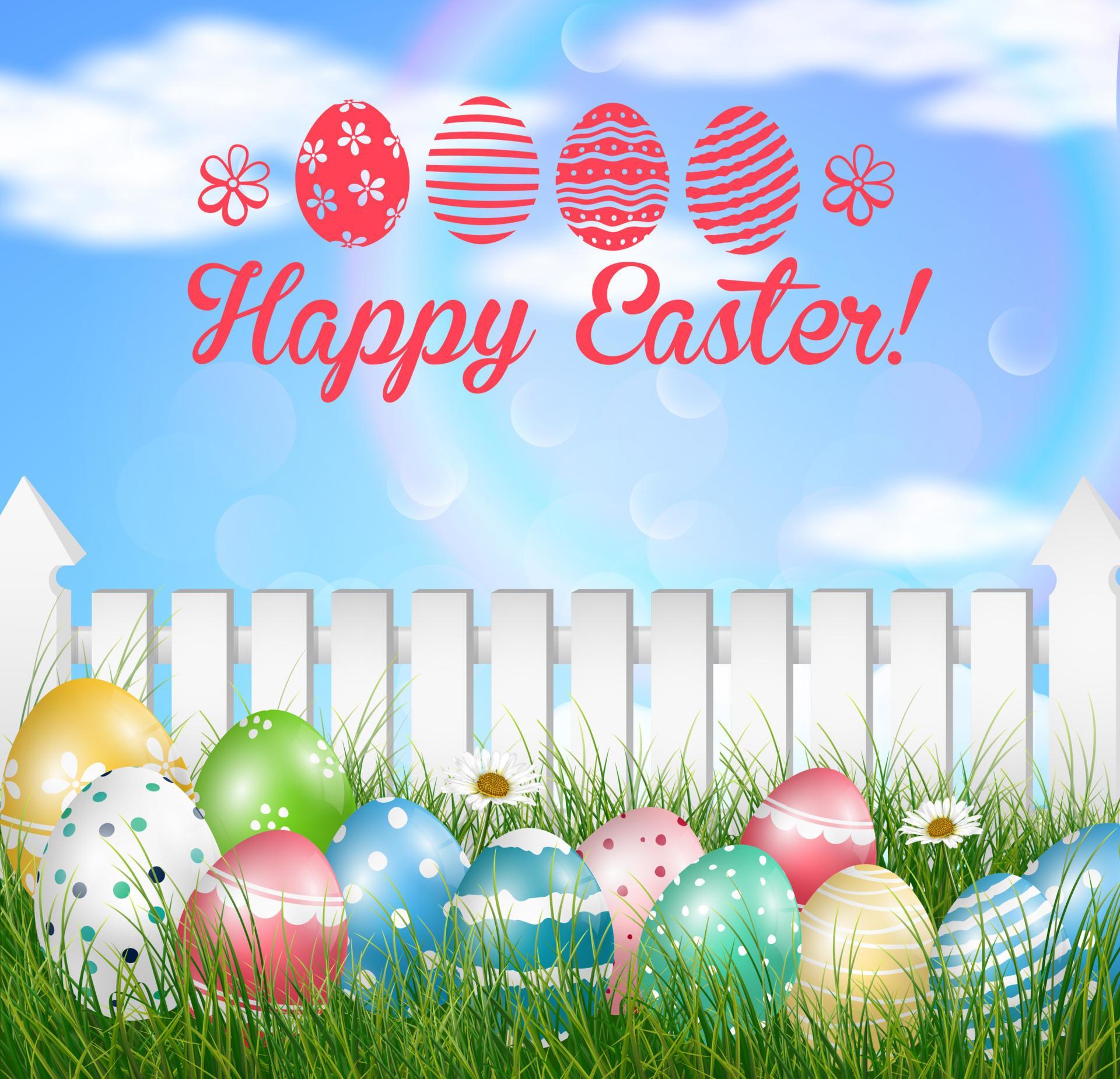 Easter eggs on a grass field with flower on wooden white fence background Stock Free