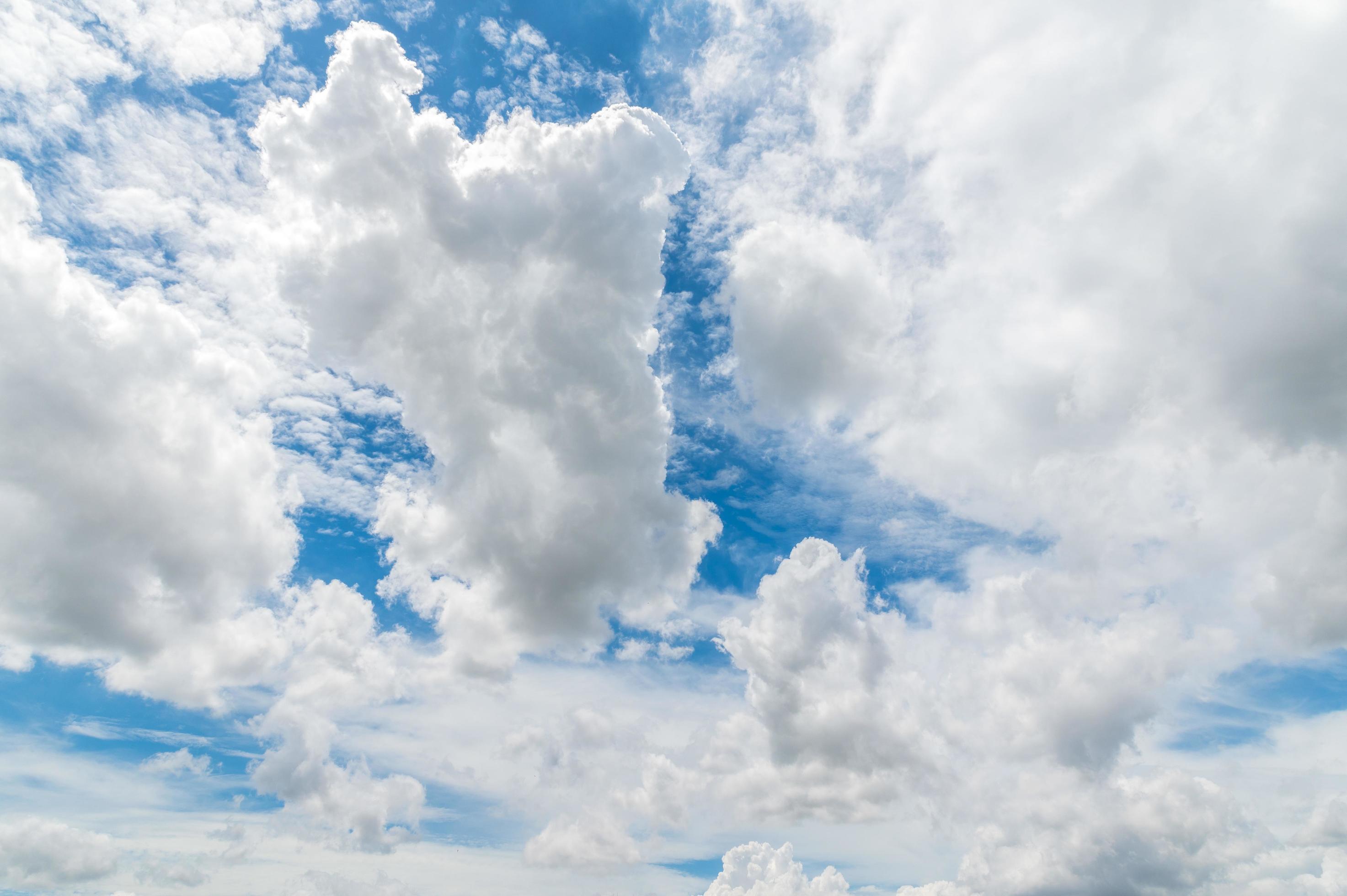 Nature background from white clouds in sunny day. Beautiful white fluffy clouds in blue sky. Stock Free