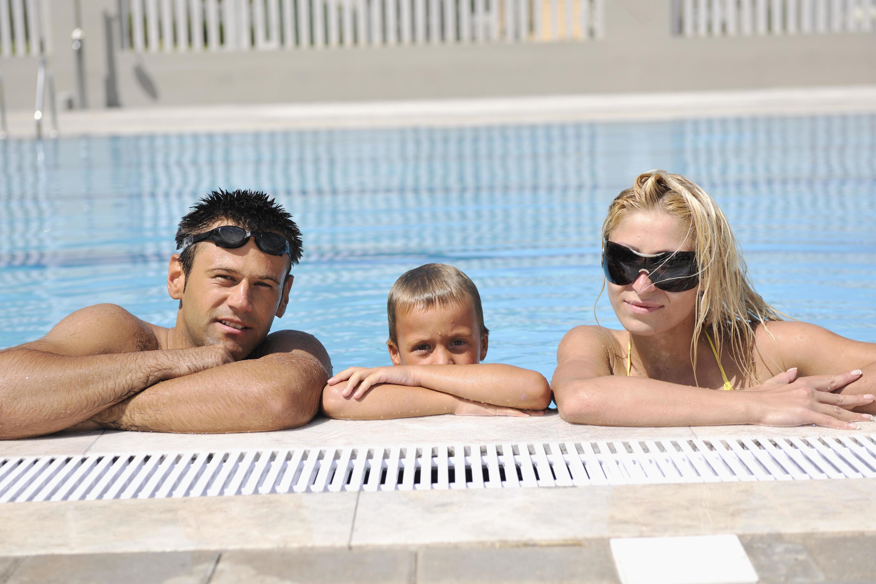 happy young family have fun on swimming pool Stock Free