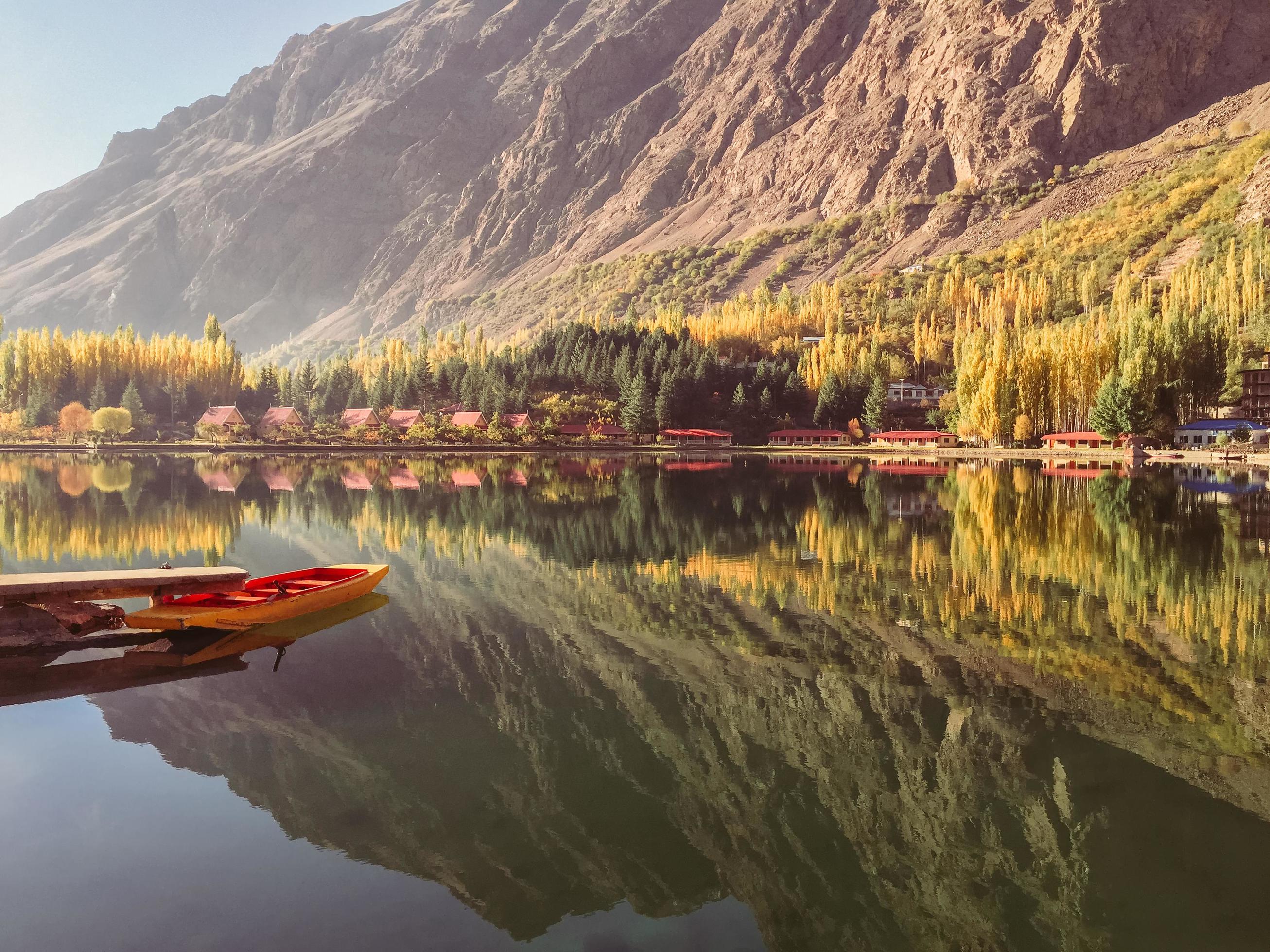 View of docked boat on still water with mountains in background Stock Free