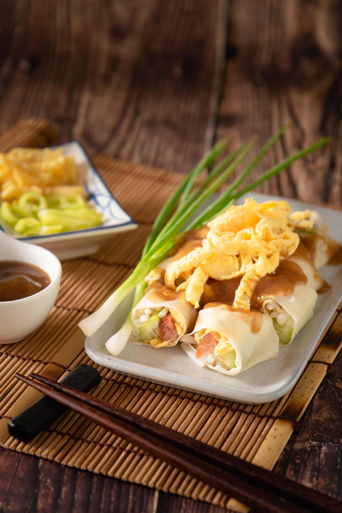 Thai traditional fresh spring roll with sweet sauce, stuff vegetable and sweet sausage on wooden background Stock Free