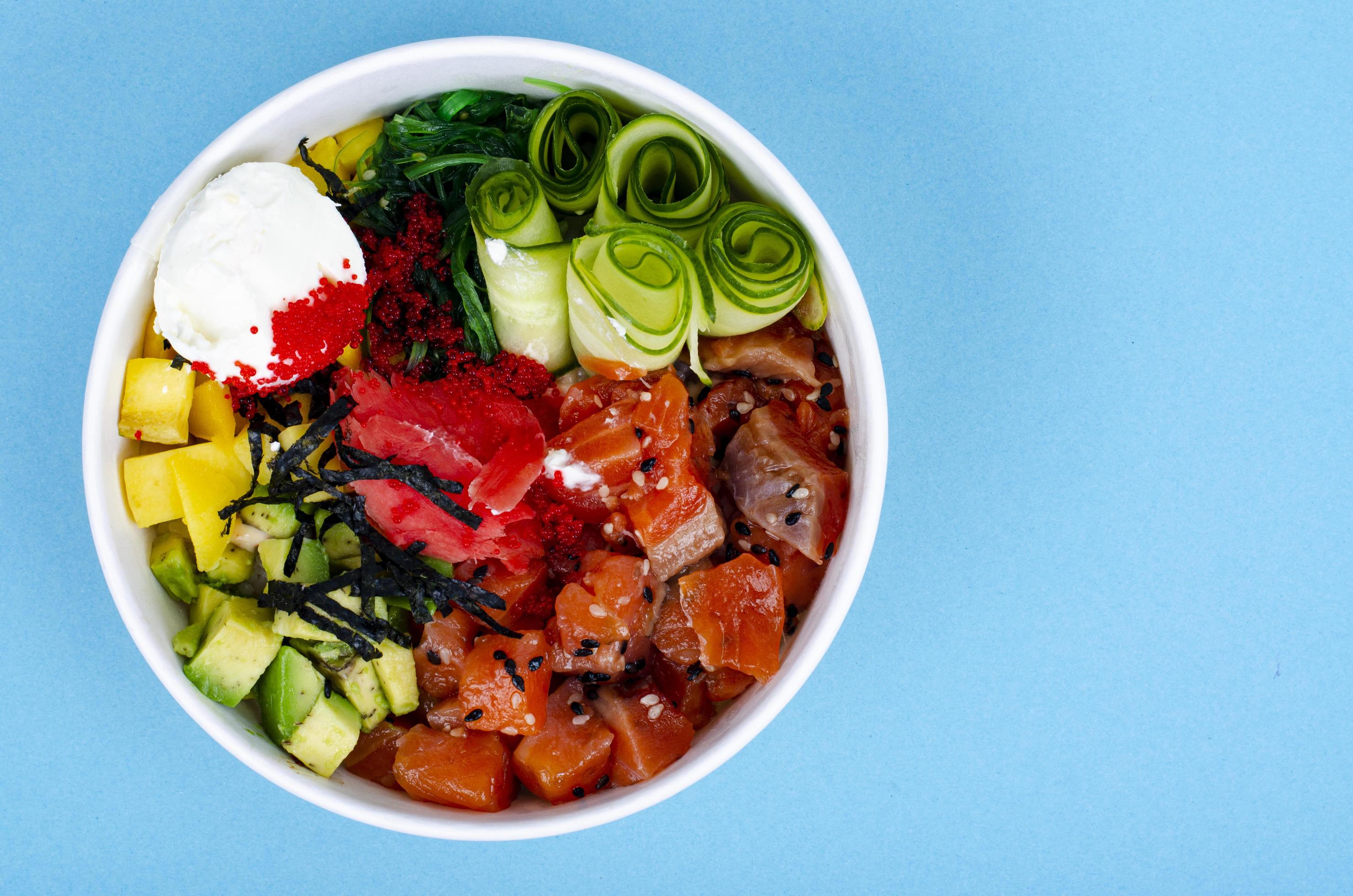 Poke with sea food and vegetables on blue background. Studio Photo Stock Free