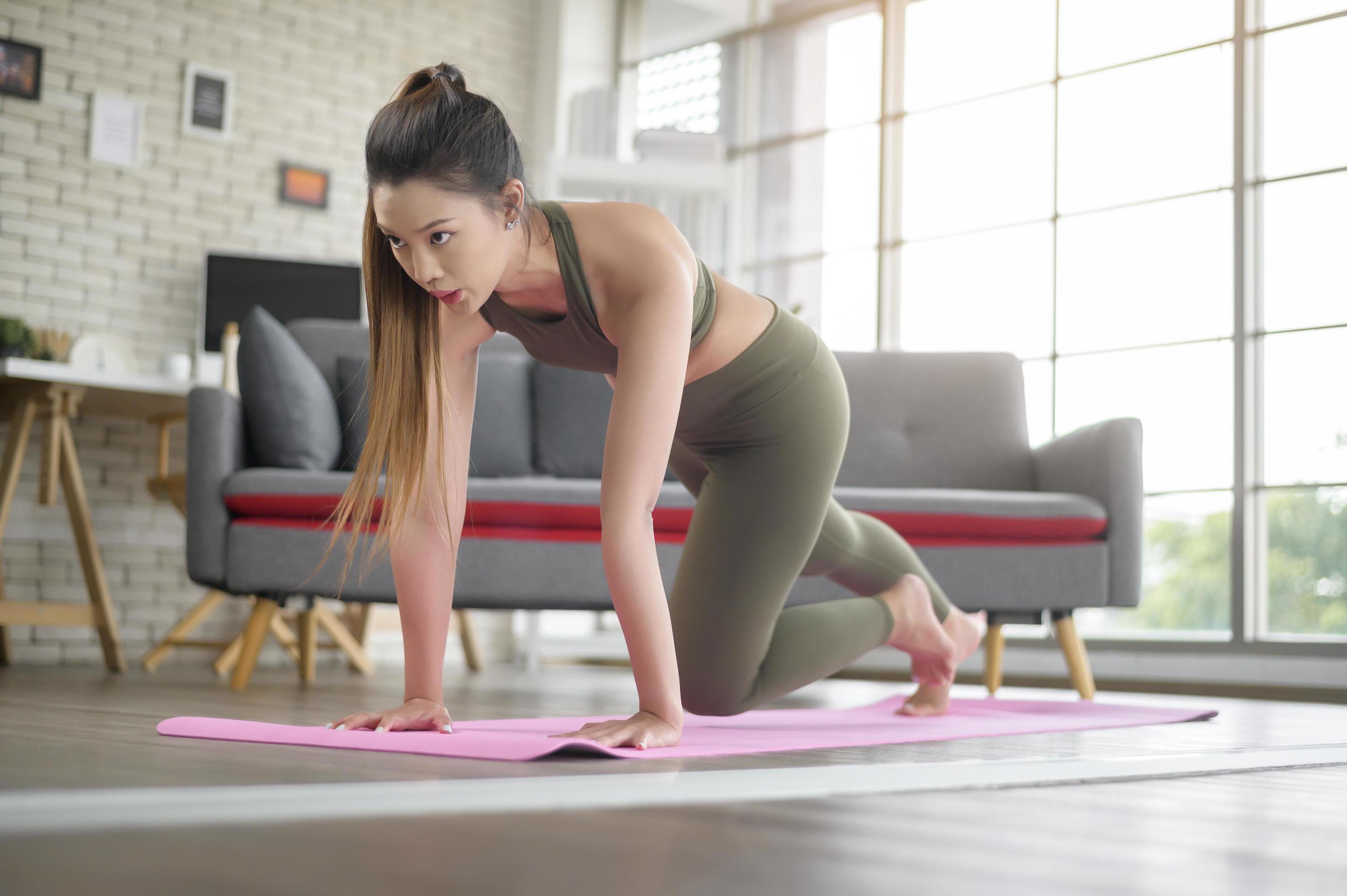 Young fitness woman in sportswear exercising at home, Healthy and Lifestyles. Stock Free