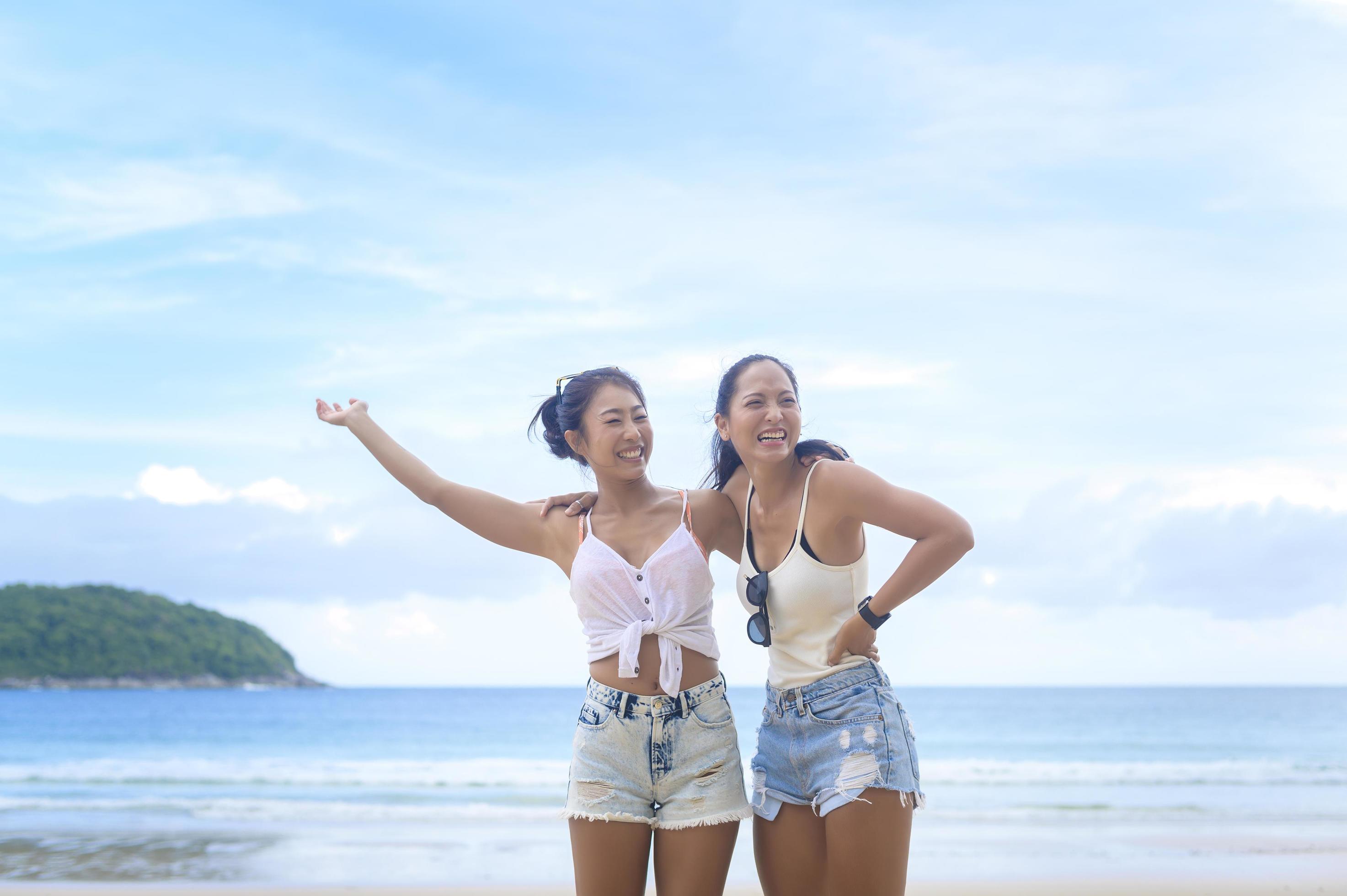 Two attractive women friends enjoying and relaxing on the beach, Summer, vacation, holidays, Lifestyles concept. Stock Free