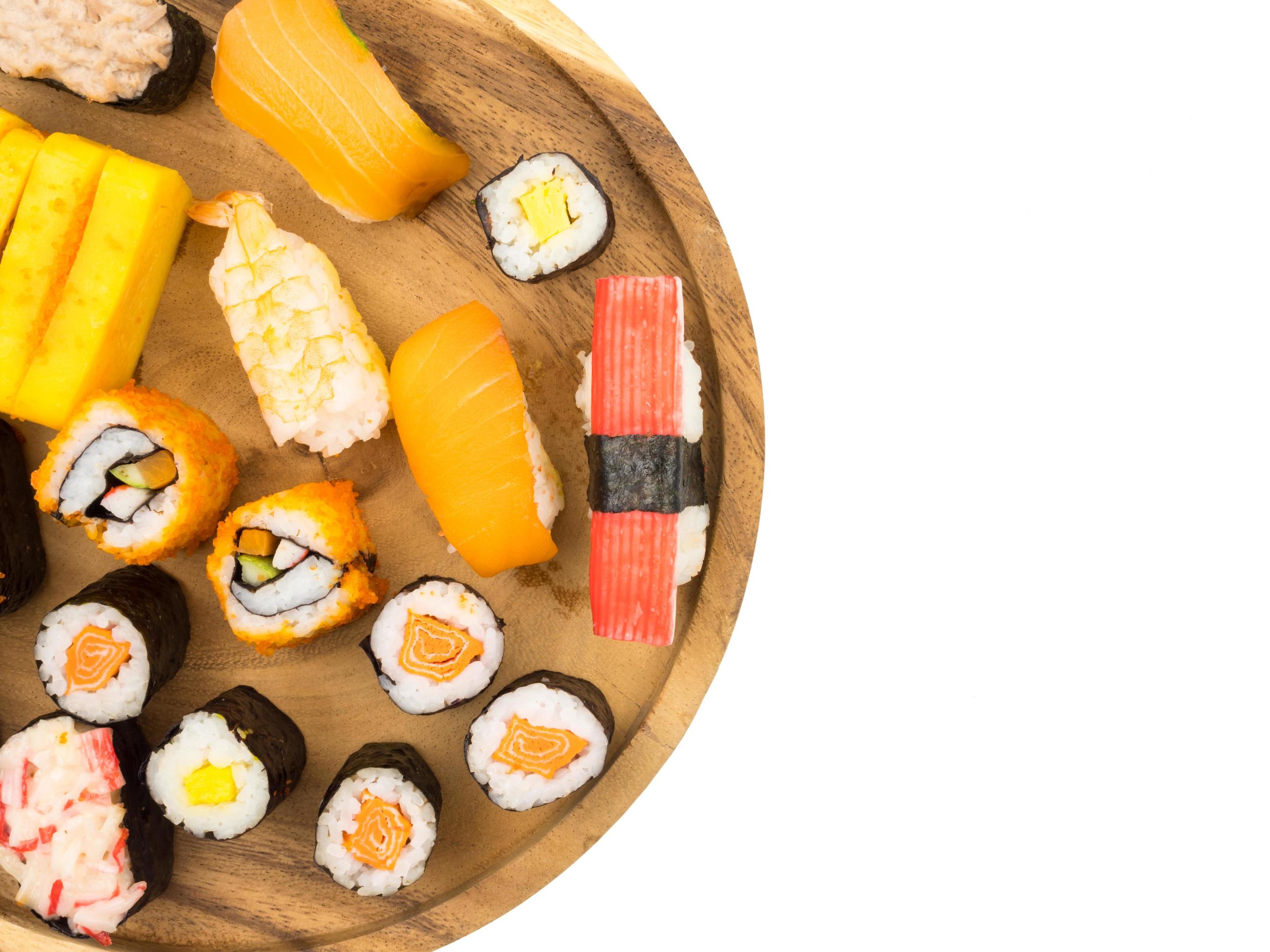 Top view of Sushi set on wooden plate on white background, Japanese food. Free space for text Stock Free