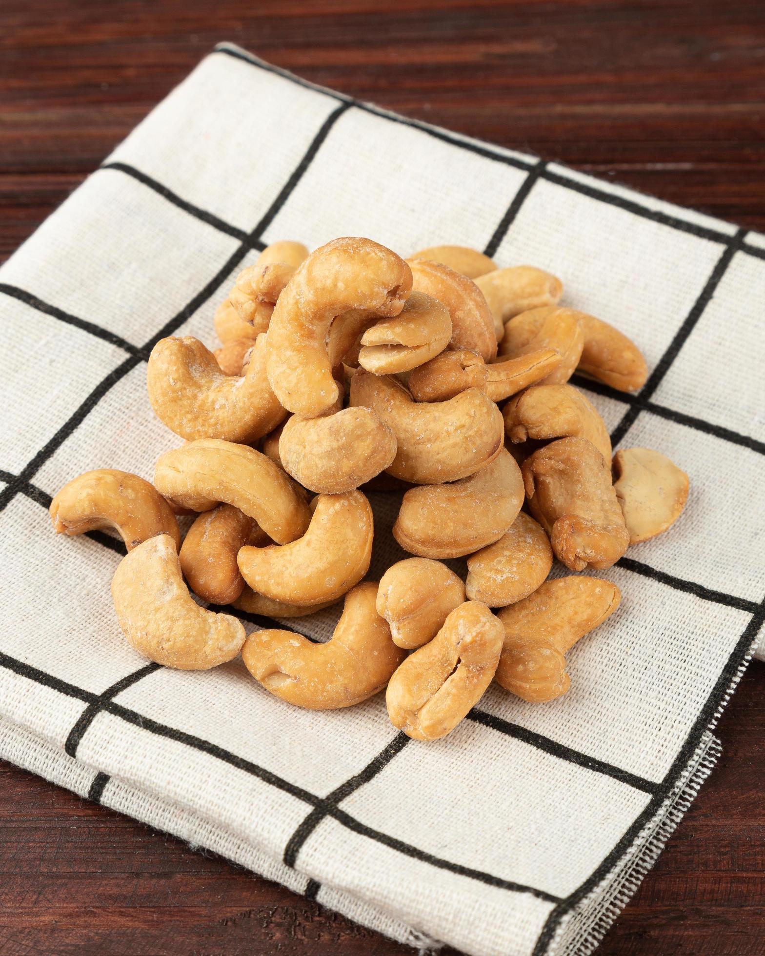 Cashew nuts in tablecloth on wooden table, Healthy snack, Vegetarian food Stock Free