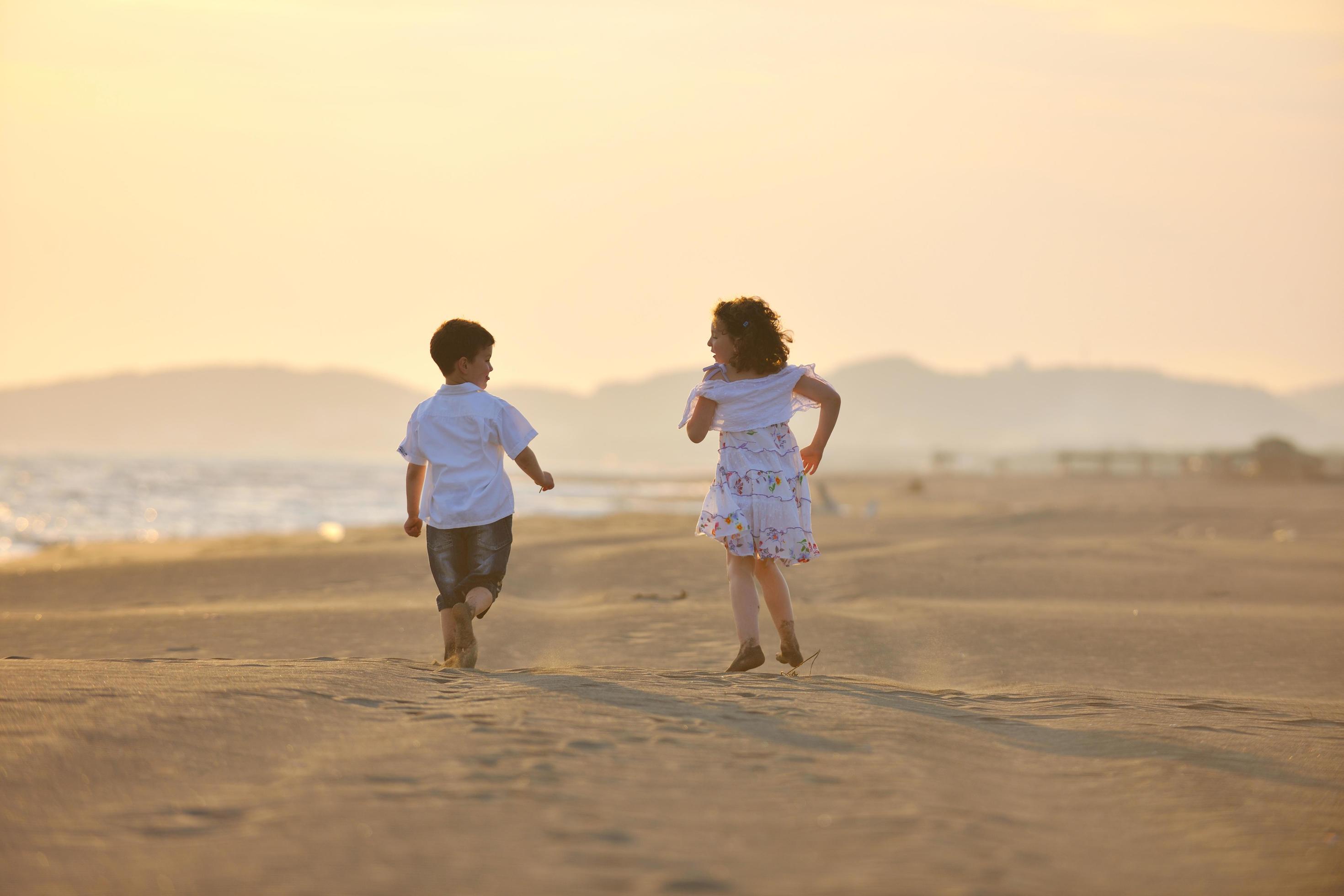 happy young family have fun on beach at sunset Stock Free