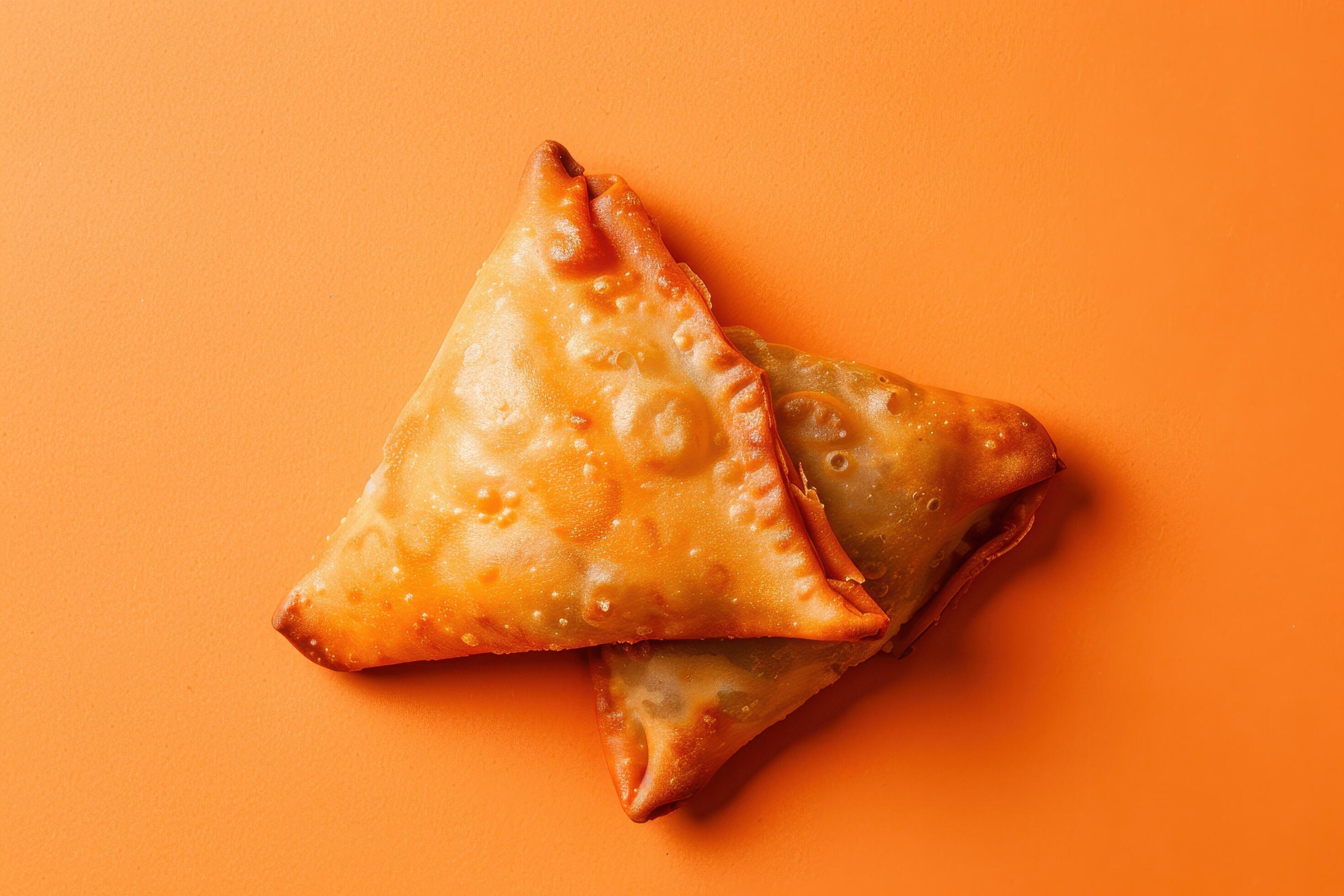 Two Golden Brown Fried Samosas on Orange Background Stock Free