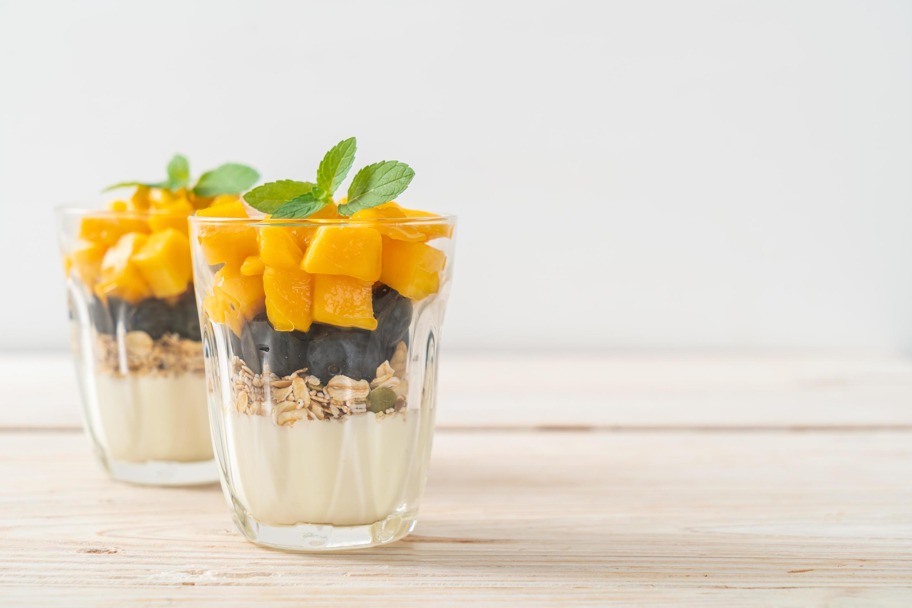 Homemade fresh mango and fresh blueberry with yogurt and granola – healthy food style Stock Free