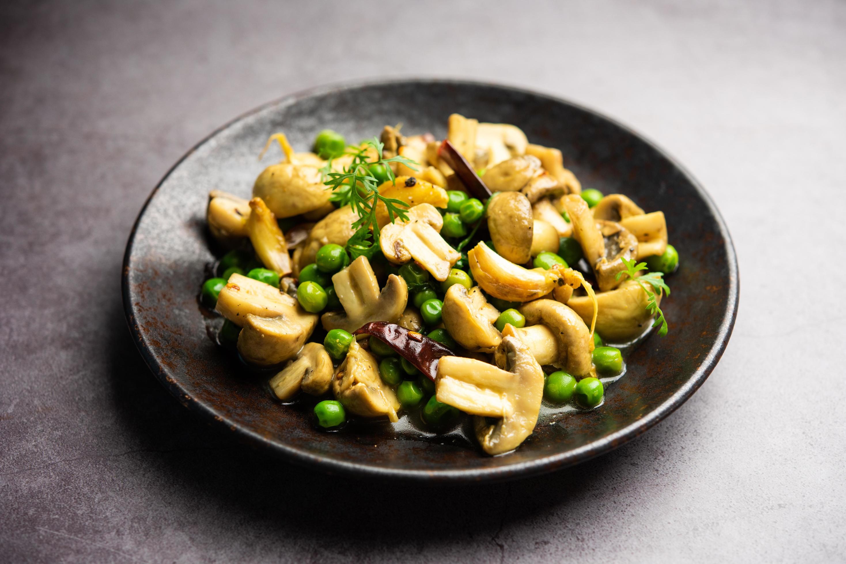 Mushroom and Pea Curry with Roasted Garlic, Indian food served in a bowl Stock Free