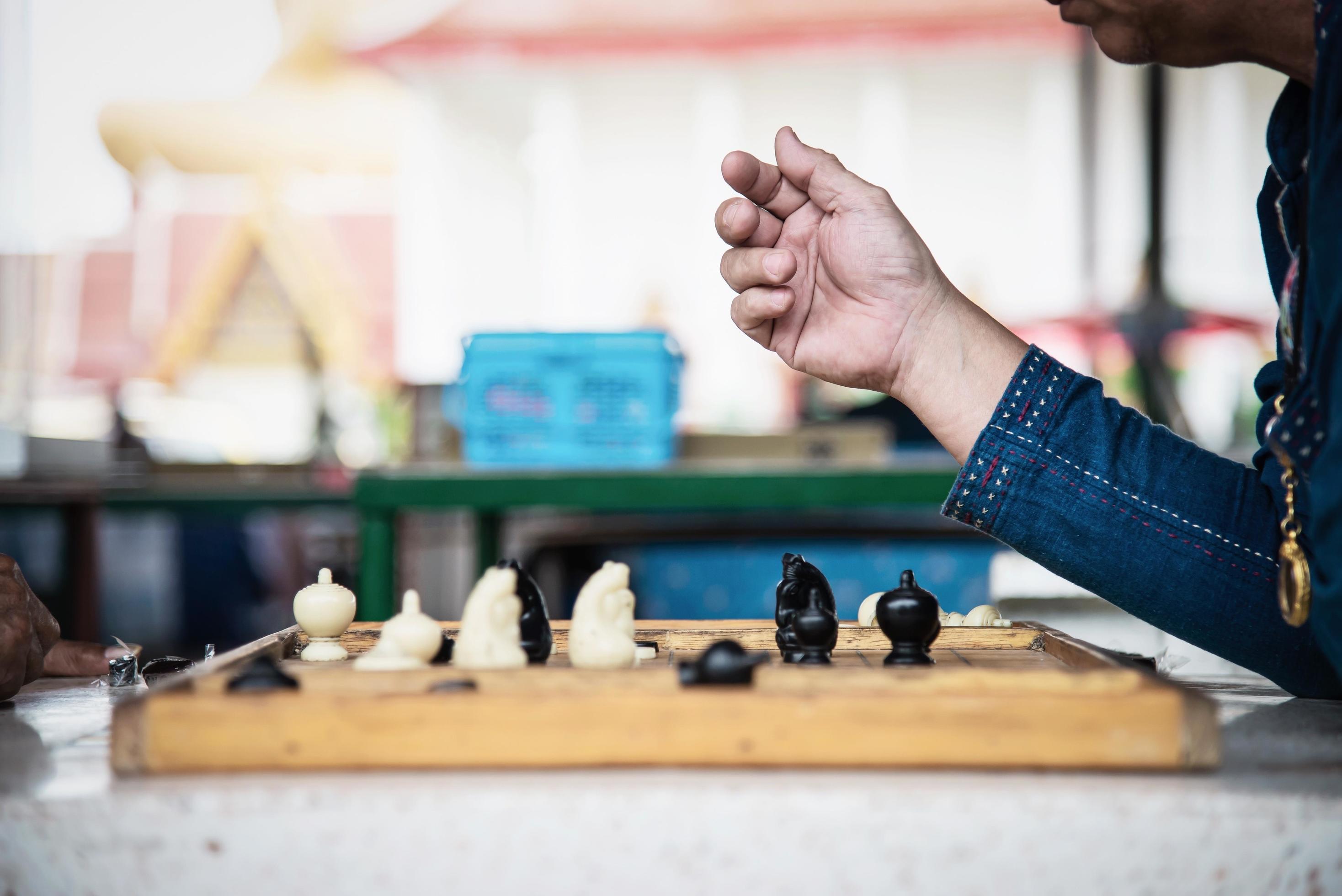 Local Thai people play old traditional Thai chess in public area – slow life style local people with chess board game concept Stock Free