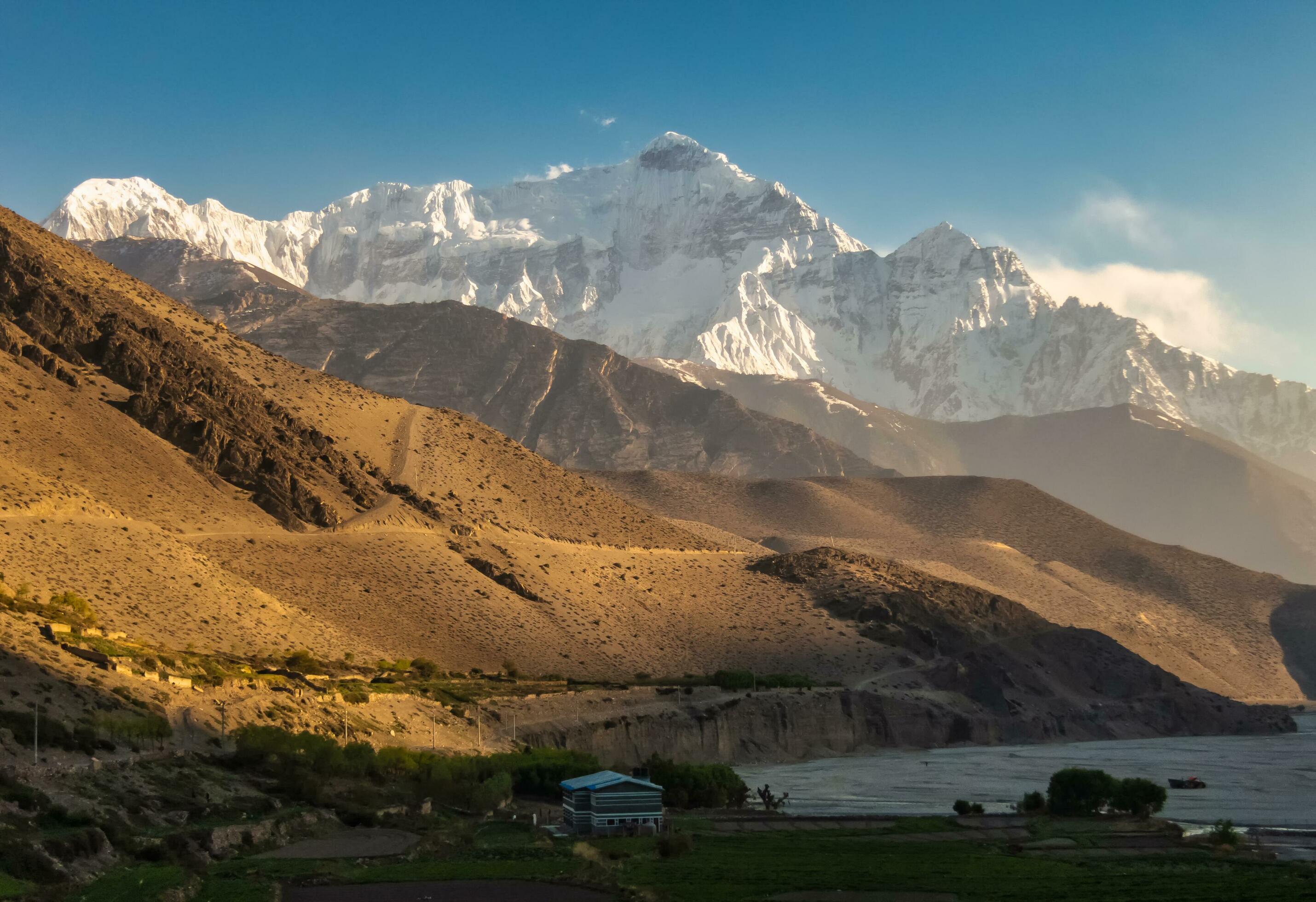 A snow capped mountain peak above the village of Kagbeni in Nepal Stock Free