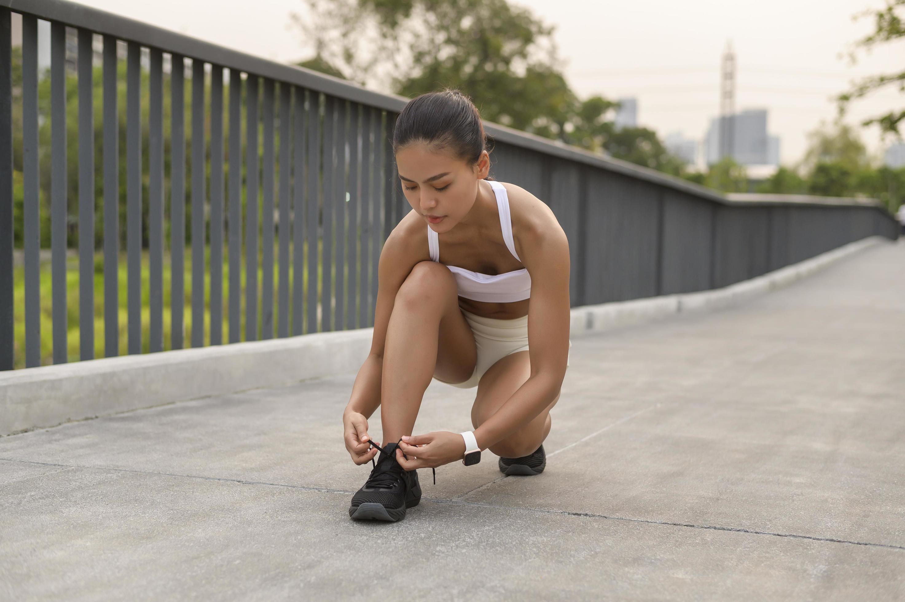 Young fitness woman in sportswear tying shoelace in city park, Healthy and Lifestyles. Stock Free