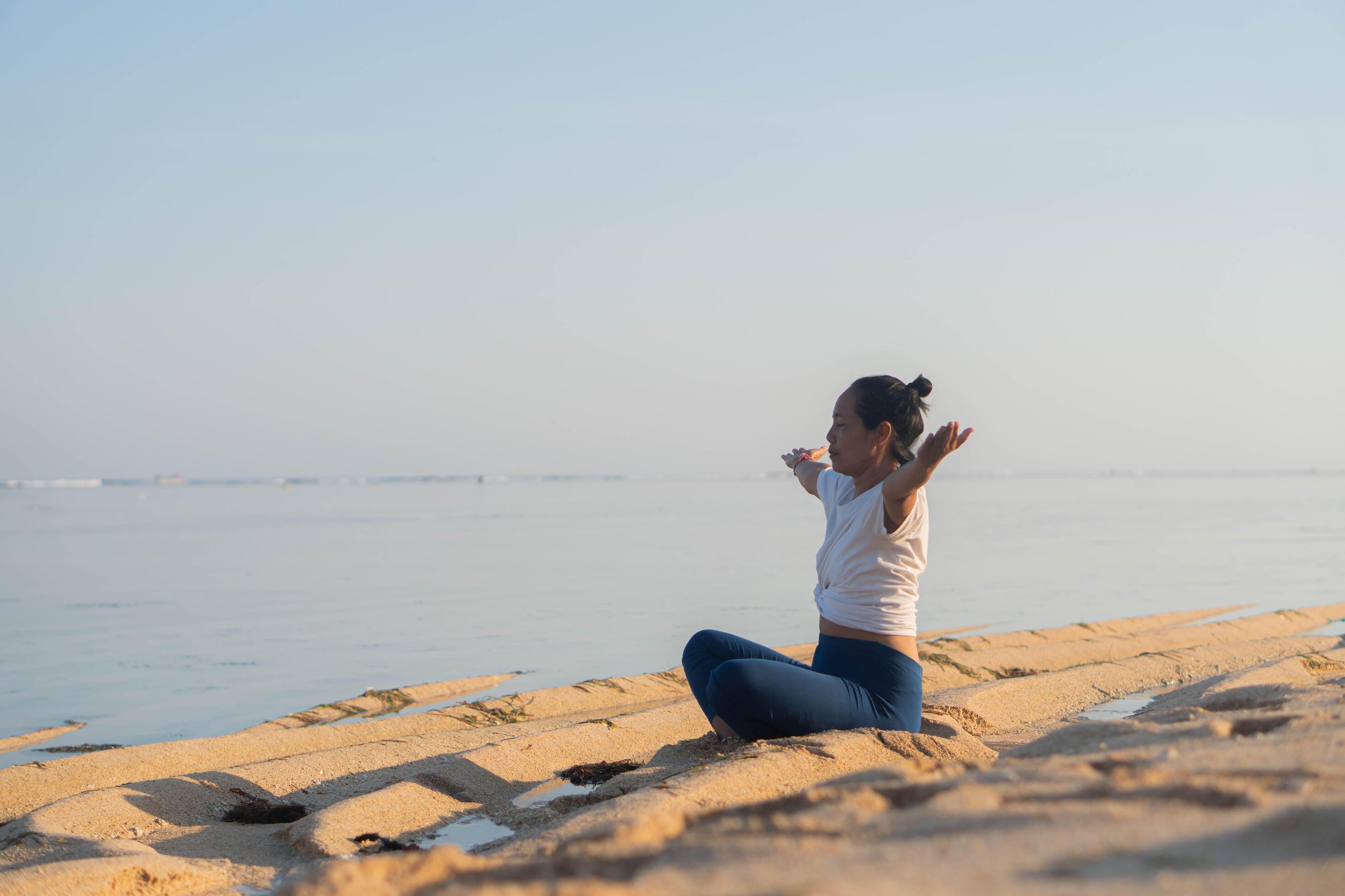 healthy woman with beautiful body doing yoga at sunrise on the beach, yoga poses Stock Free