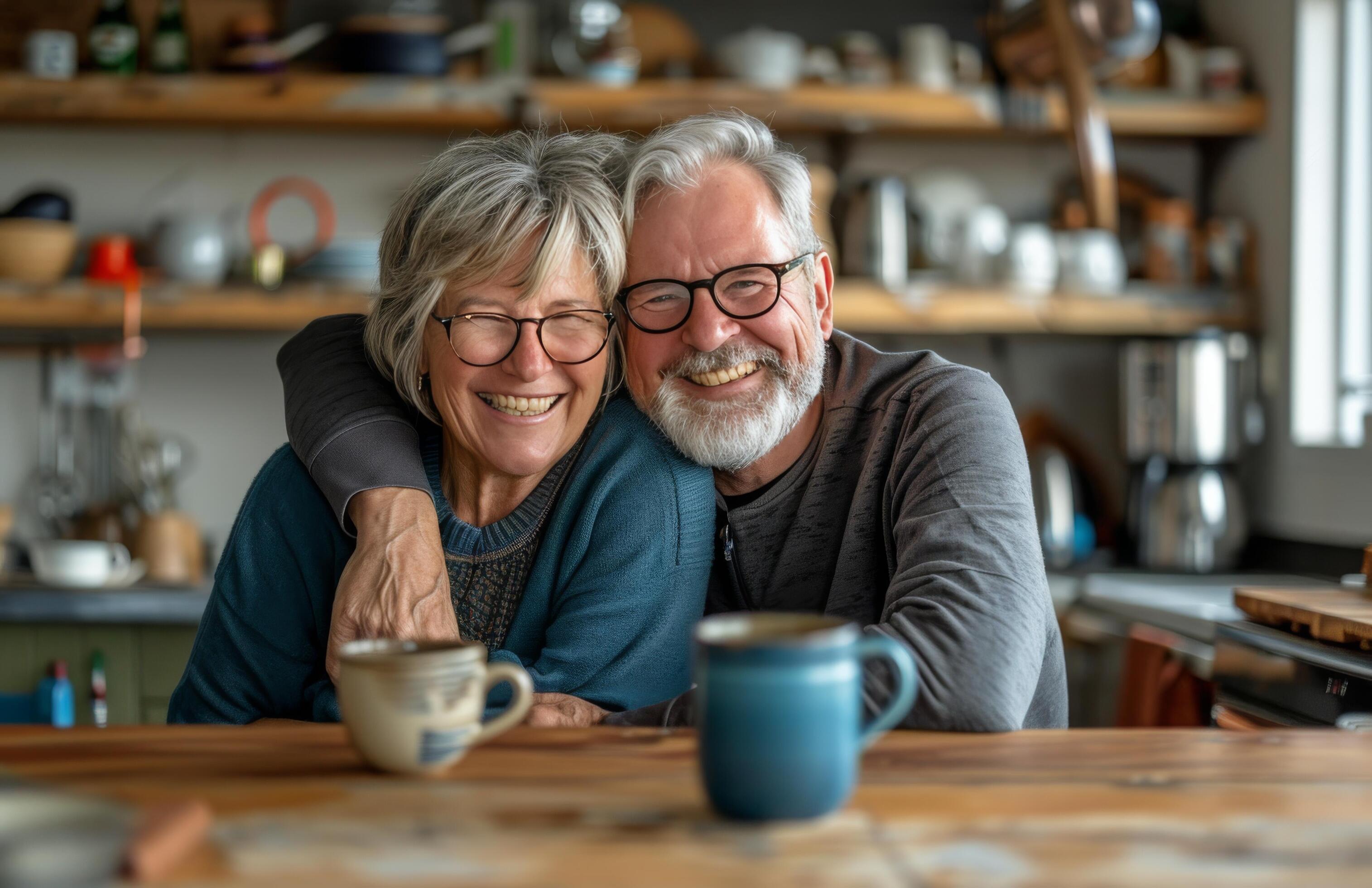 Smiling Senior Couple Enjoying Coffee Together In Their Home Kitchen Stock Free