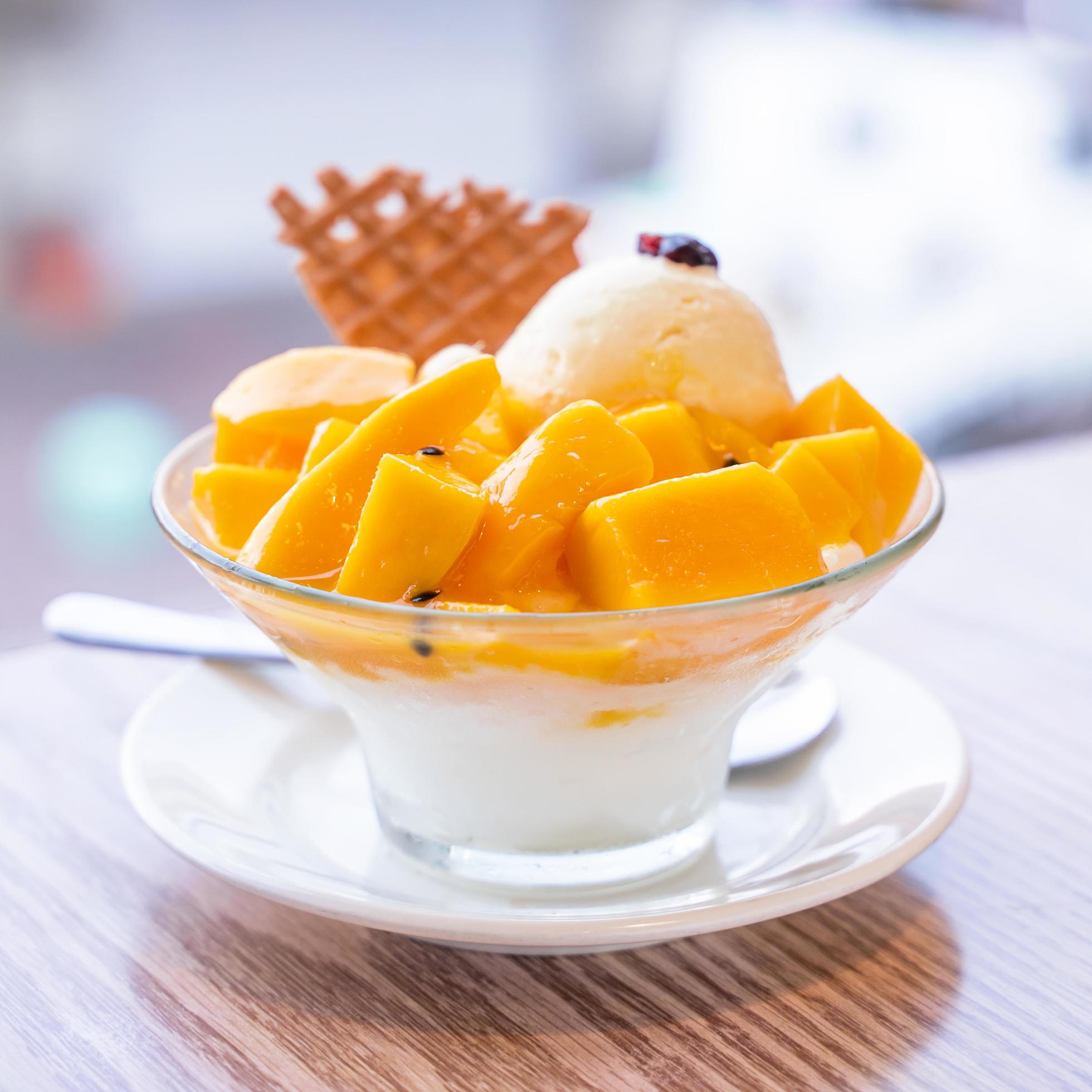 Fresh mango shaved ice with a scoop of ice cream and juice sauce in summer restaurant, lifestyle, popular food in Taiwan, close up. Stock Free