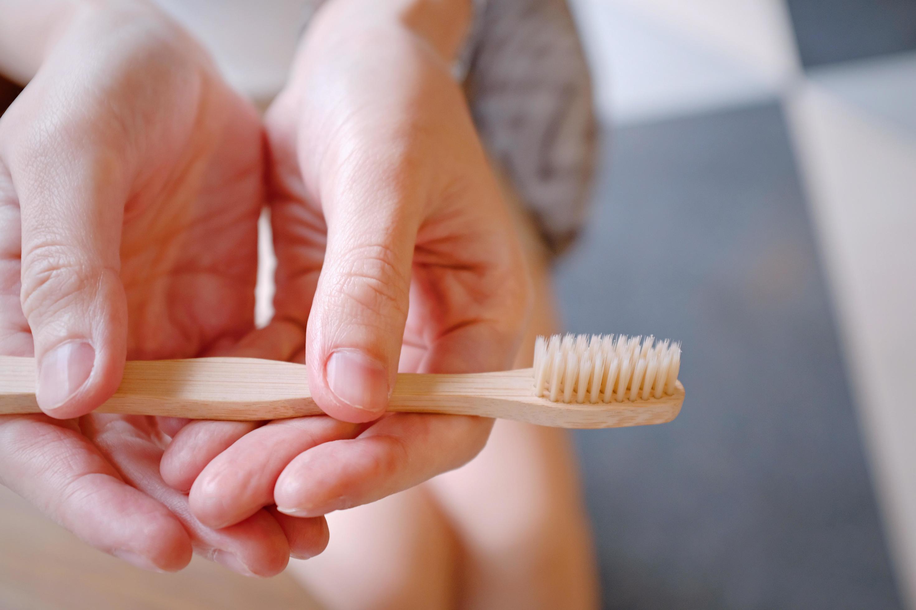 Close up of woman hands holding wooden bamboo toothbrush, sustainable lifestyle, zero waste concept Stock Free