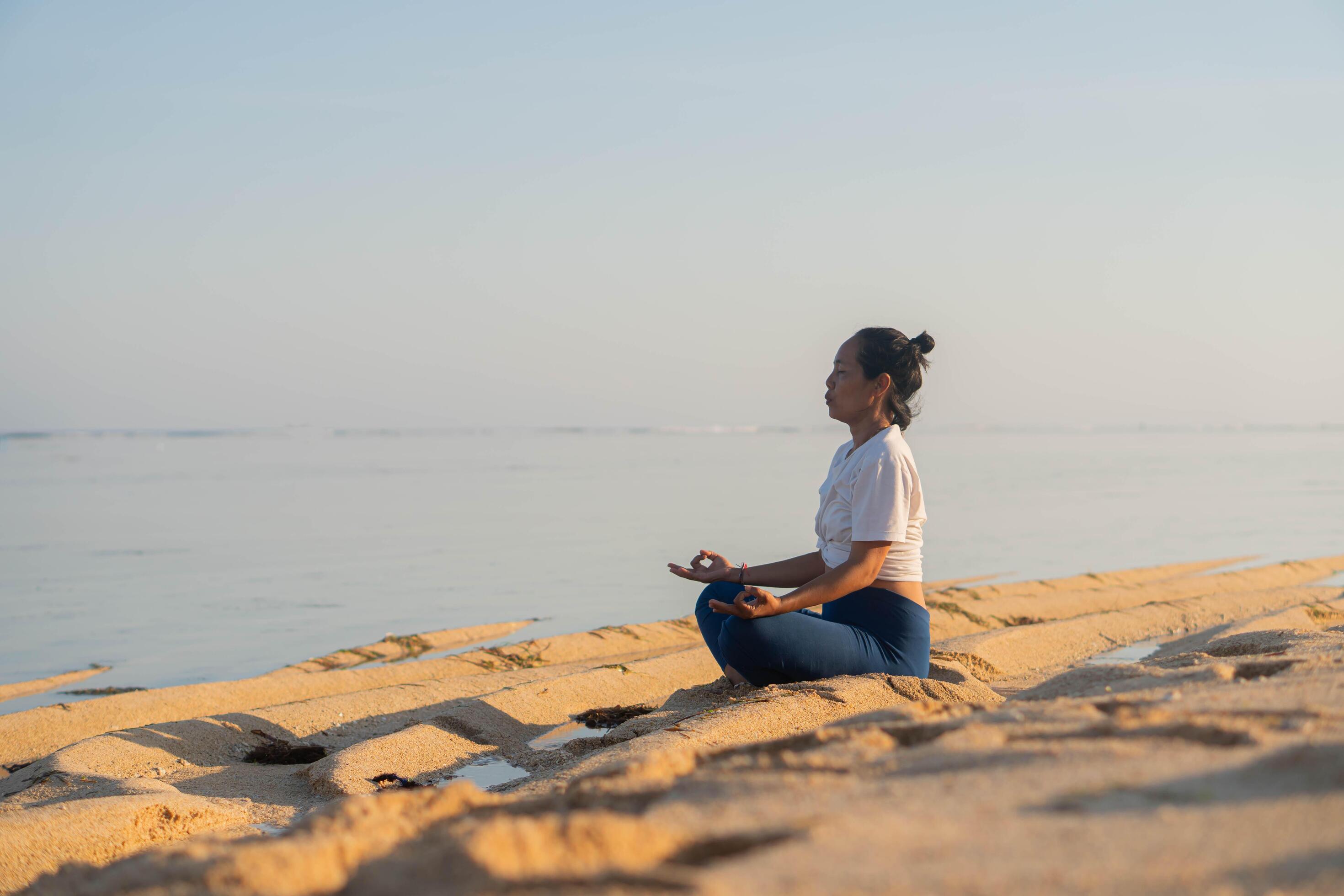 healthy woman with beautiful body doing yoga at sunrise on the beach, yoga poses Stock Free